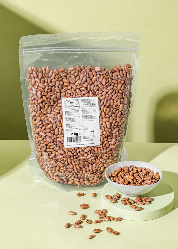 a bag of kidney beans sits next to a bowl of beans