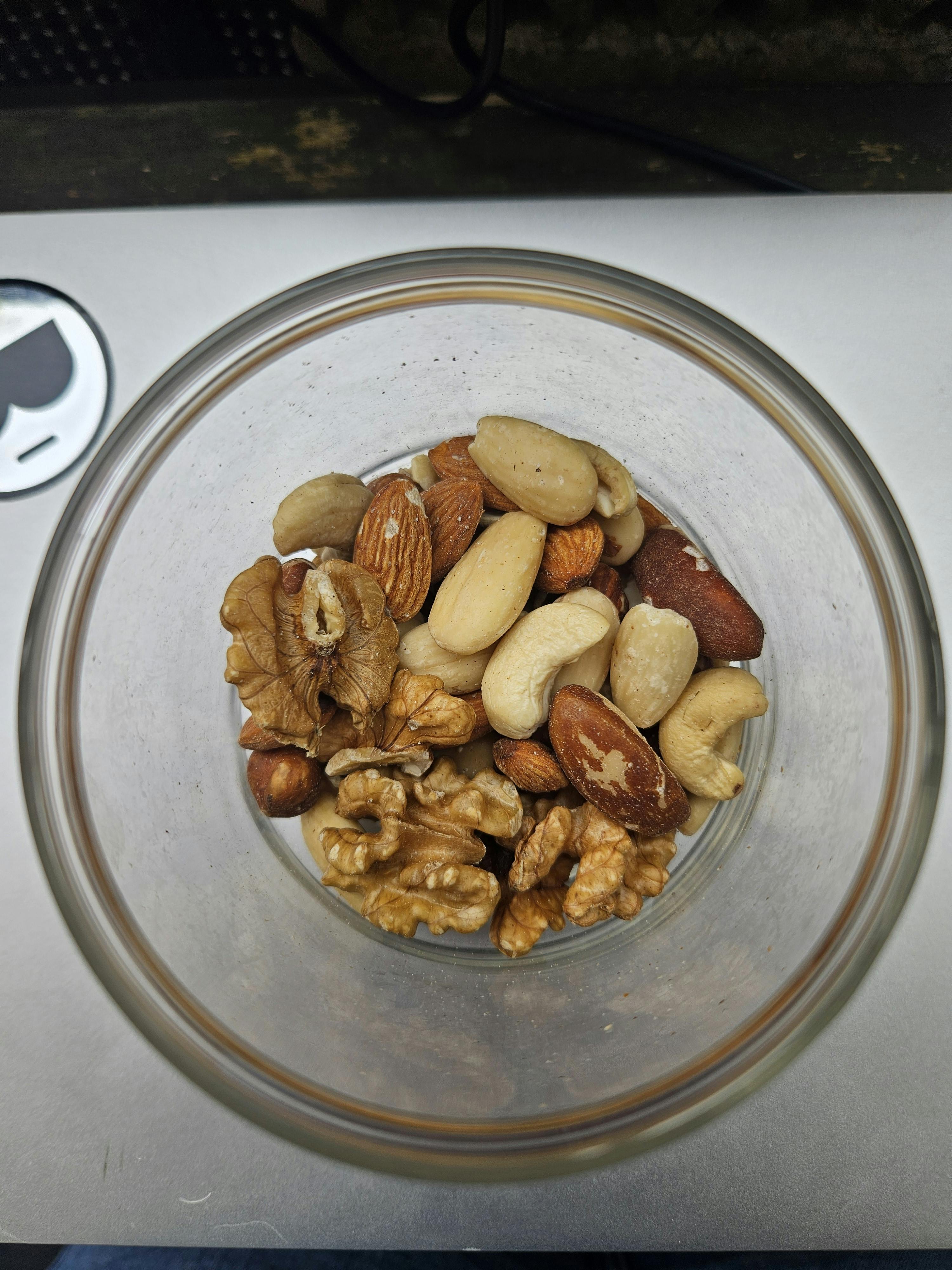 un bol en verre rempli de noix sur une table