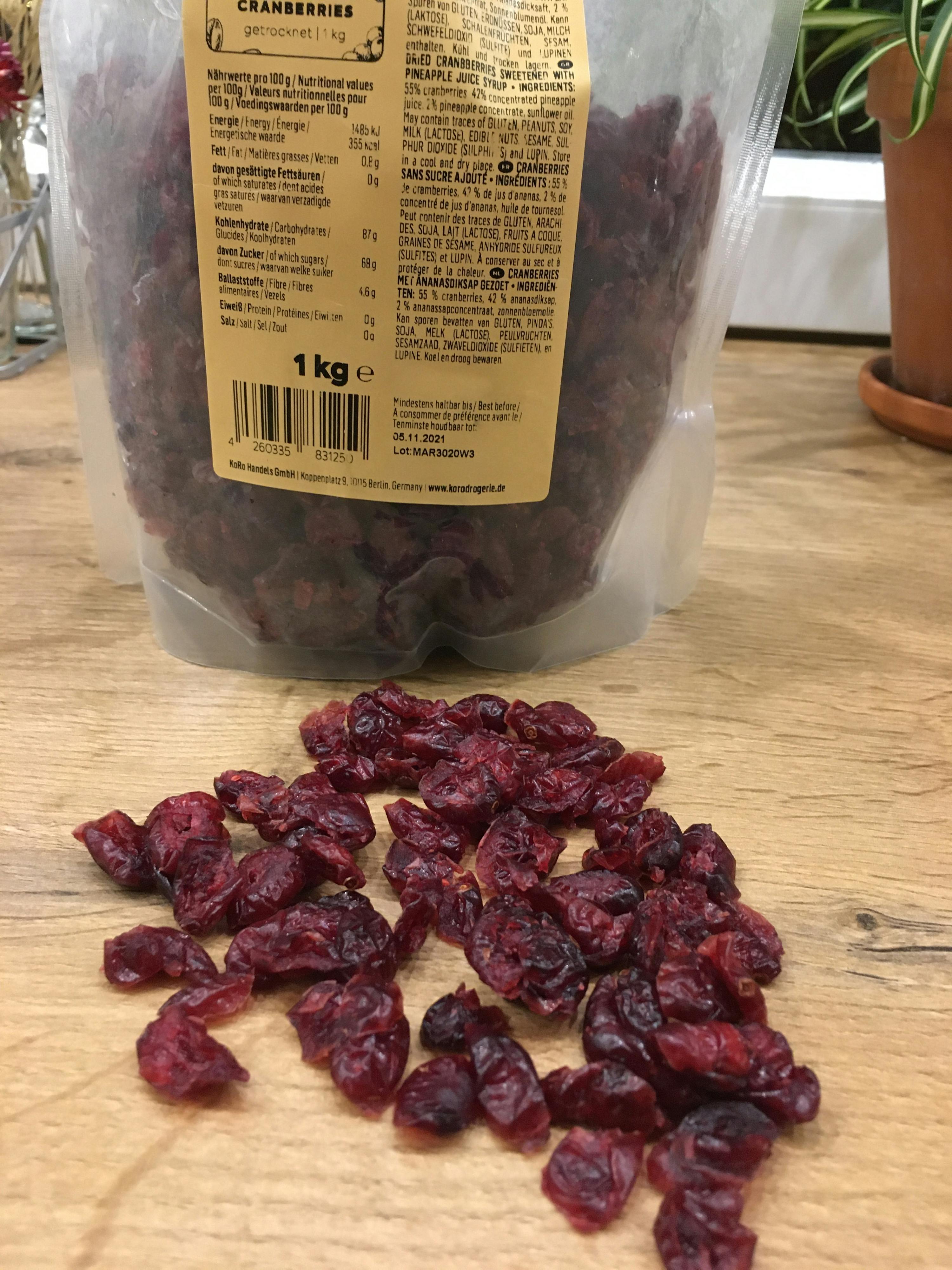 a bag of dried cranberries sits on a wooden table