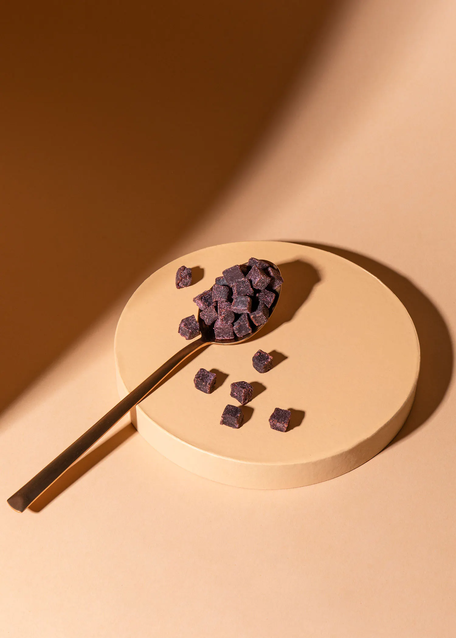 a spoon filled with purple squares on a plate