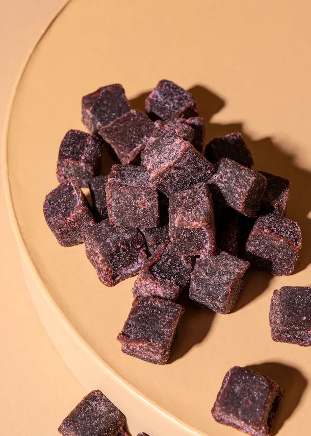 a pile of purple squares on a yellow plate