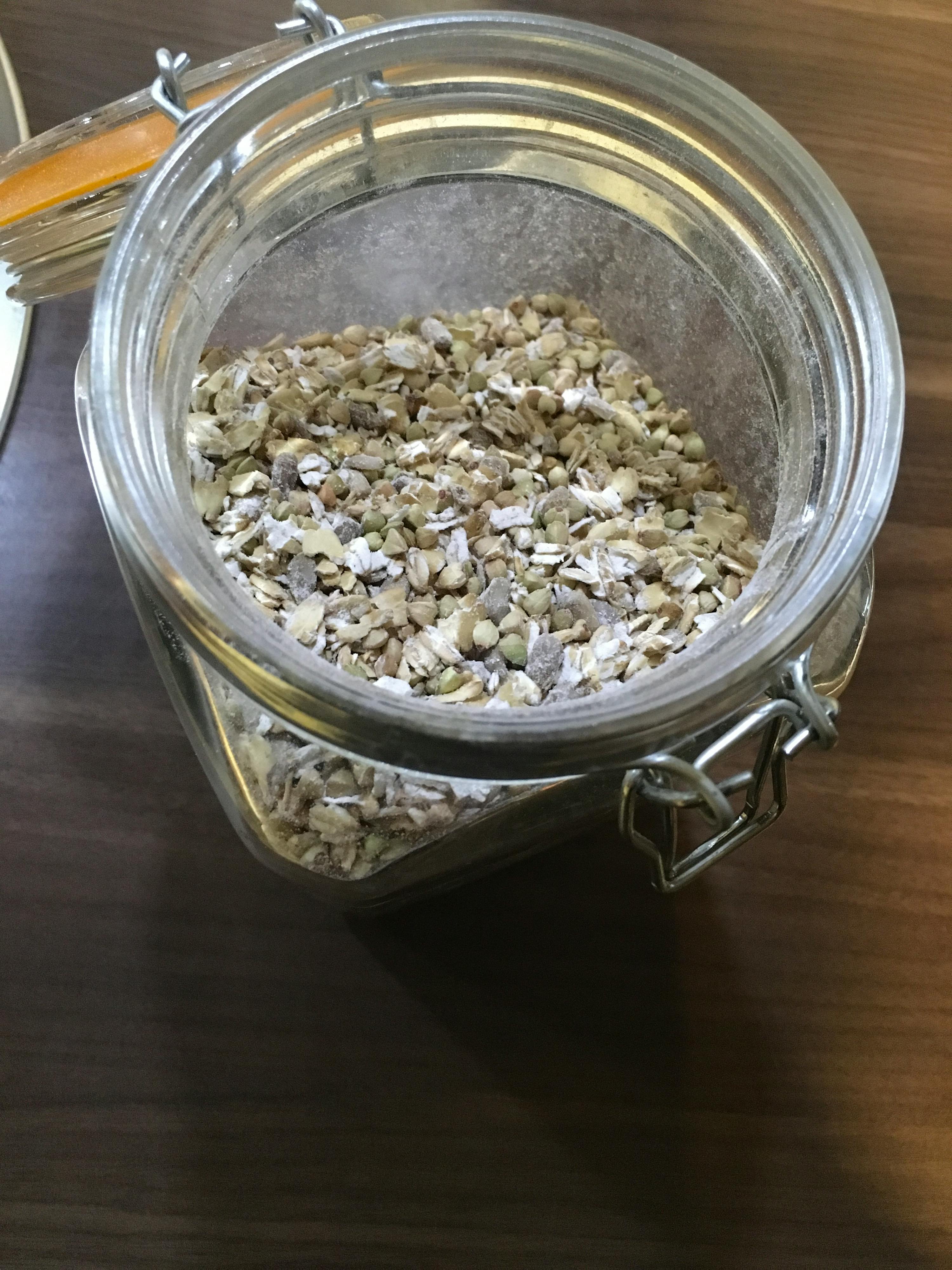 ein Glas voller Haferflocken steht auf einem Holztisch