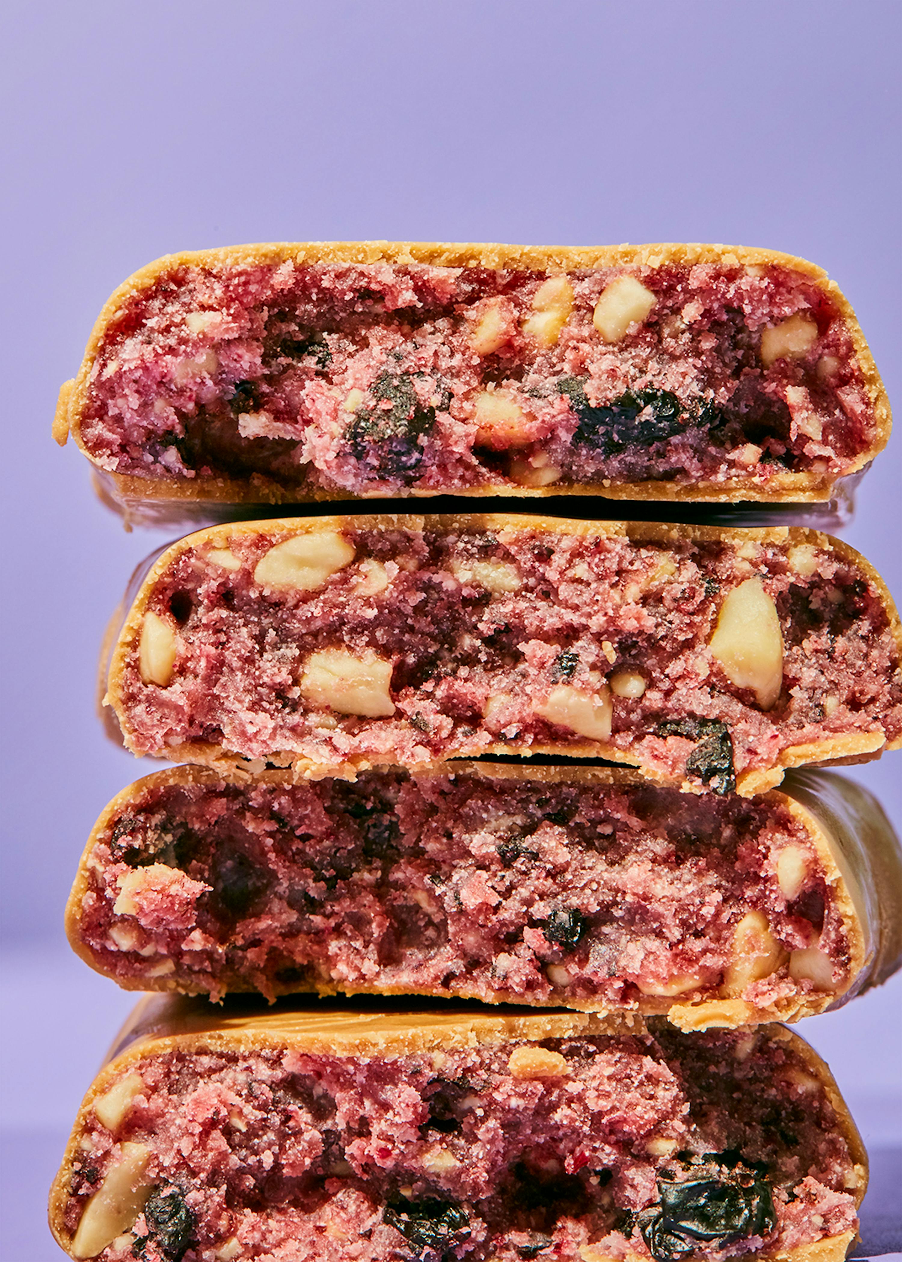 quatre biscuits empilés les uns sur les autres avec des baies et des noix