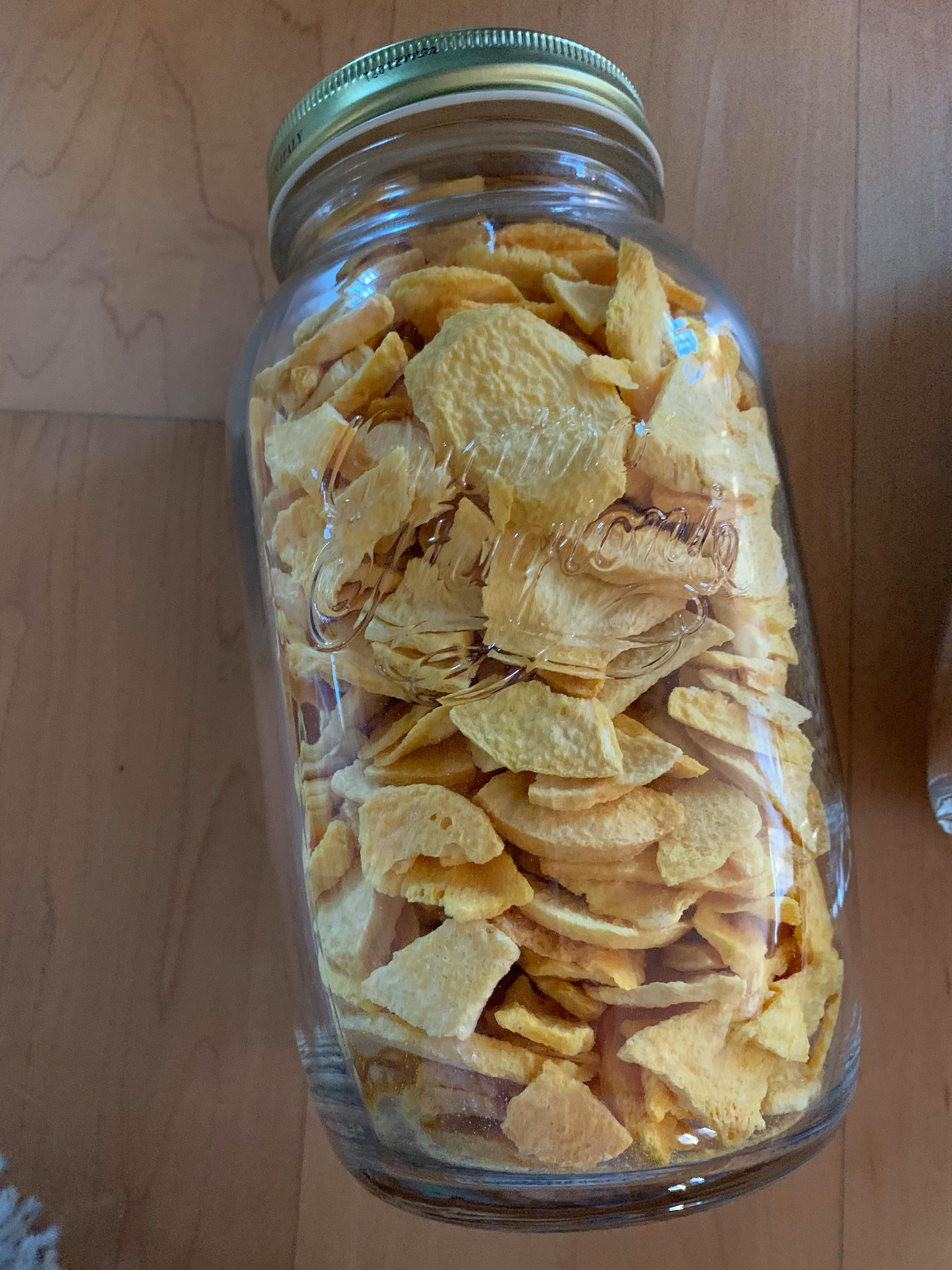 un barattolo di vetro pieno di chips di mais su un tavolo di legno