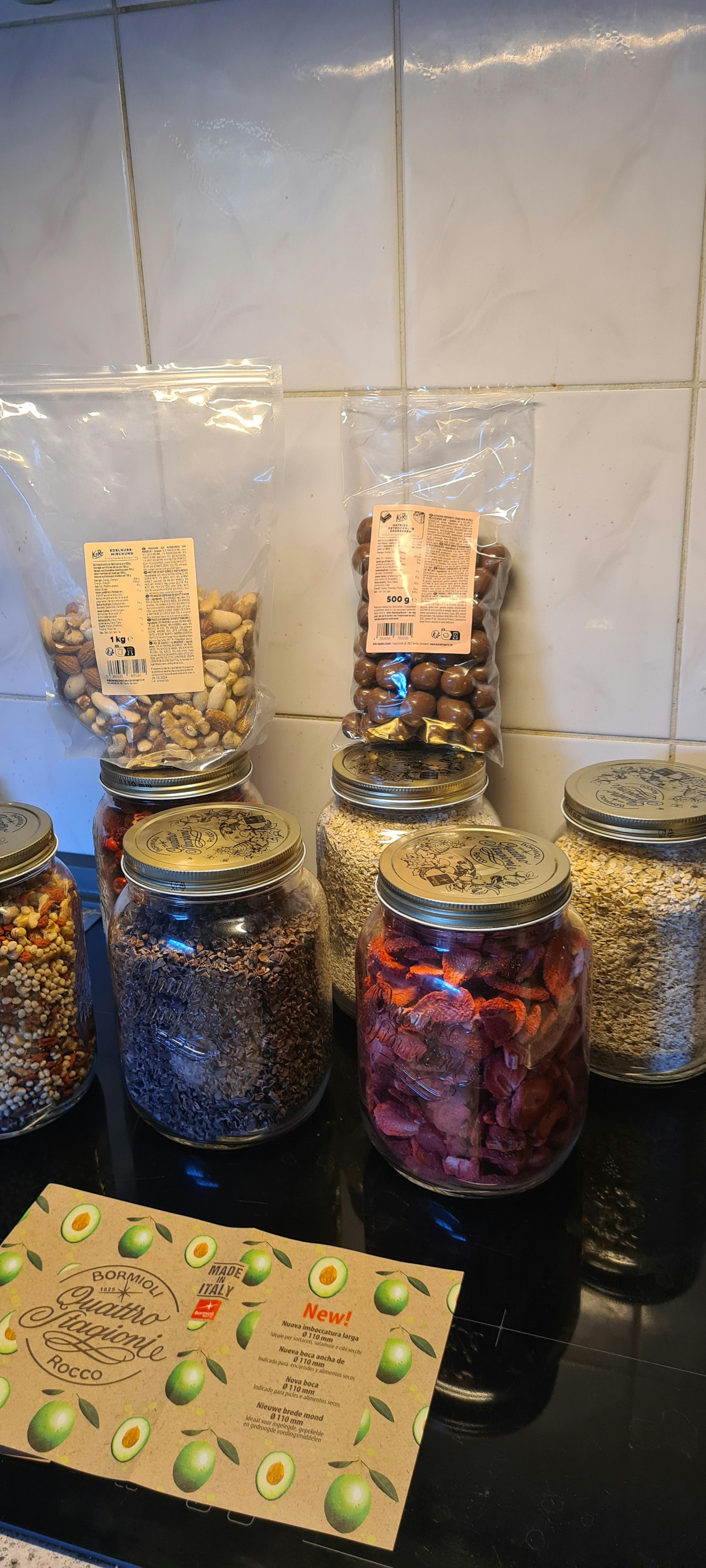 eine Reihe von Gläsern mit verschiedenen Arten von Lebensmitteln neben einer Schachtel avocados