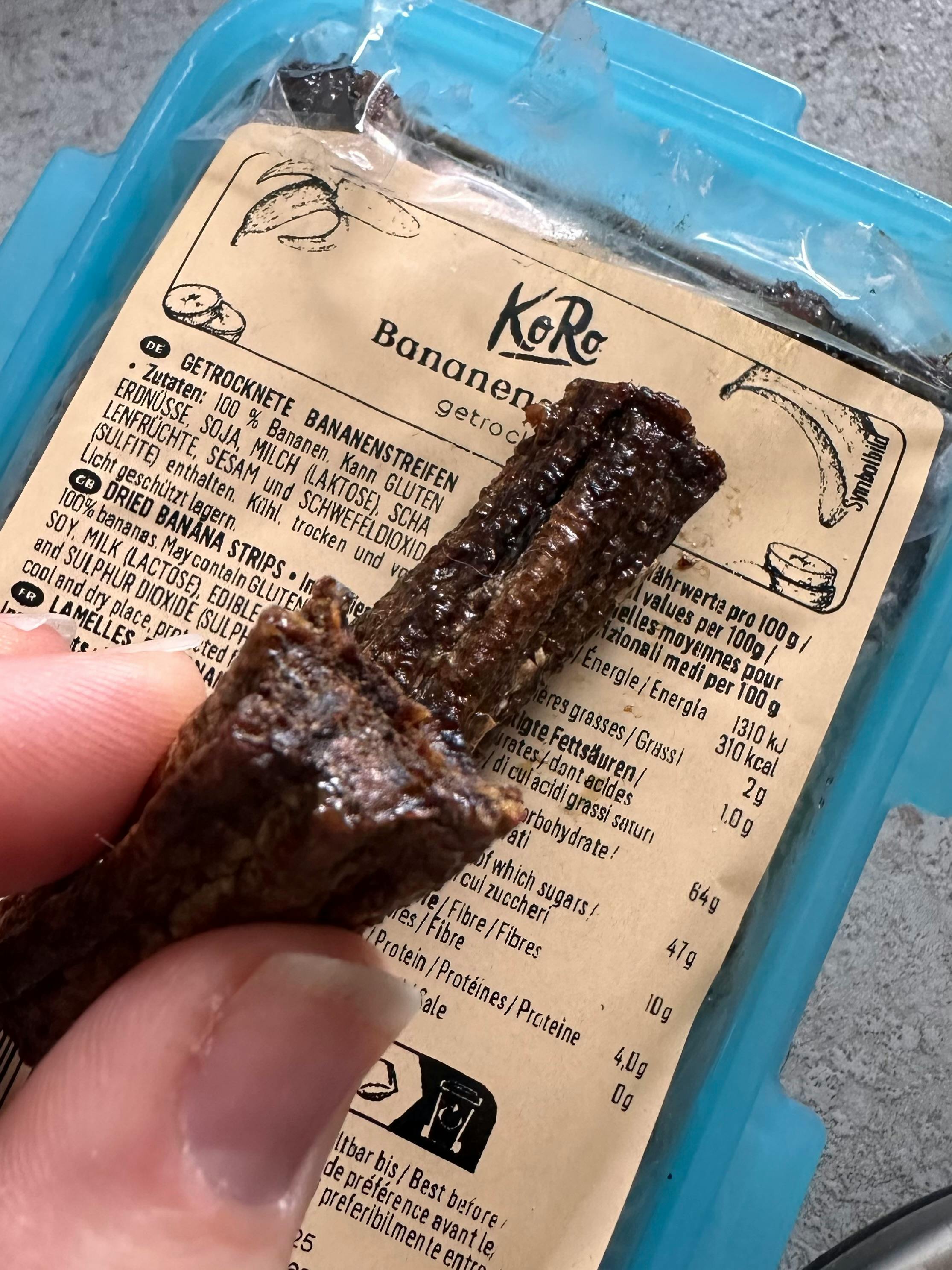 eine Person hält einen Plastikbeutel mit Bananenstreifen in der Hand