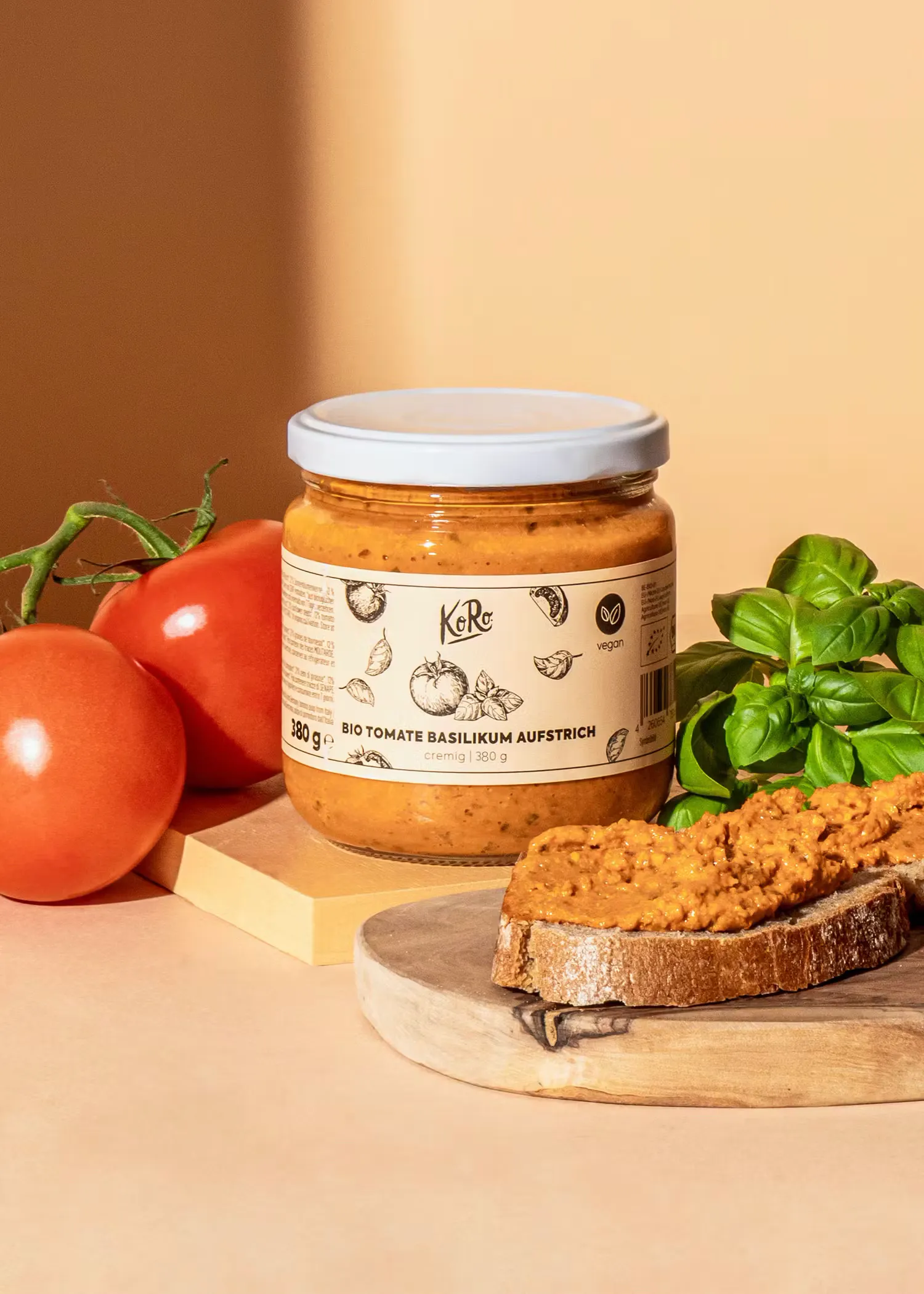 ein Glas mit Tomatenpesto steht auf einem Schneidebrett neben einem Stück Brot