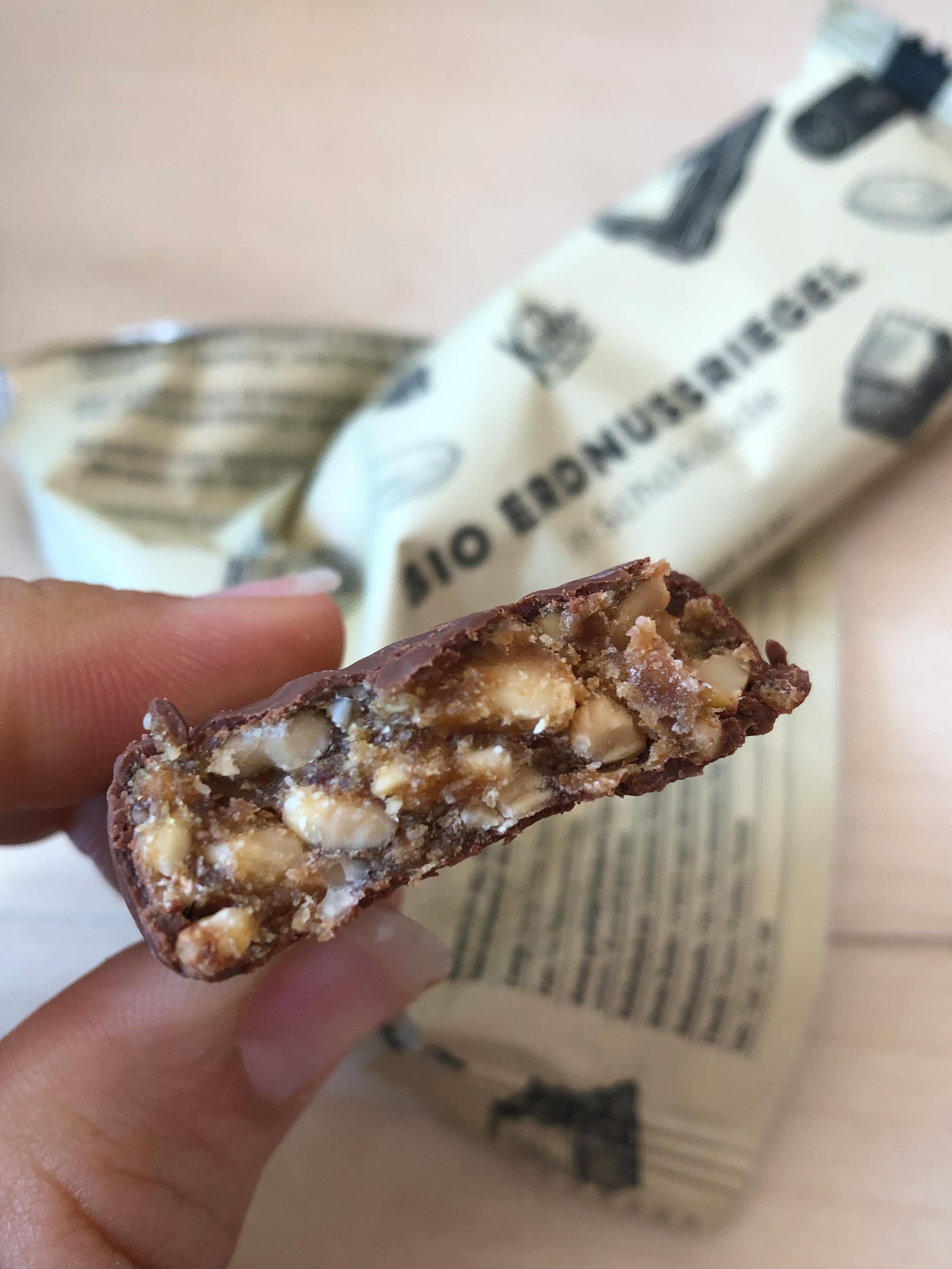 une personne tient une barre de chocolat bio avec un morceau coupé
