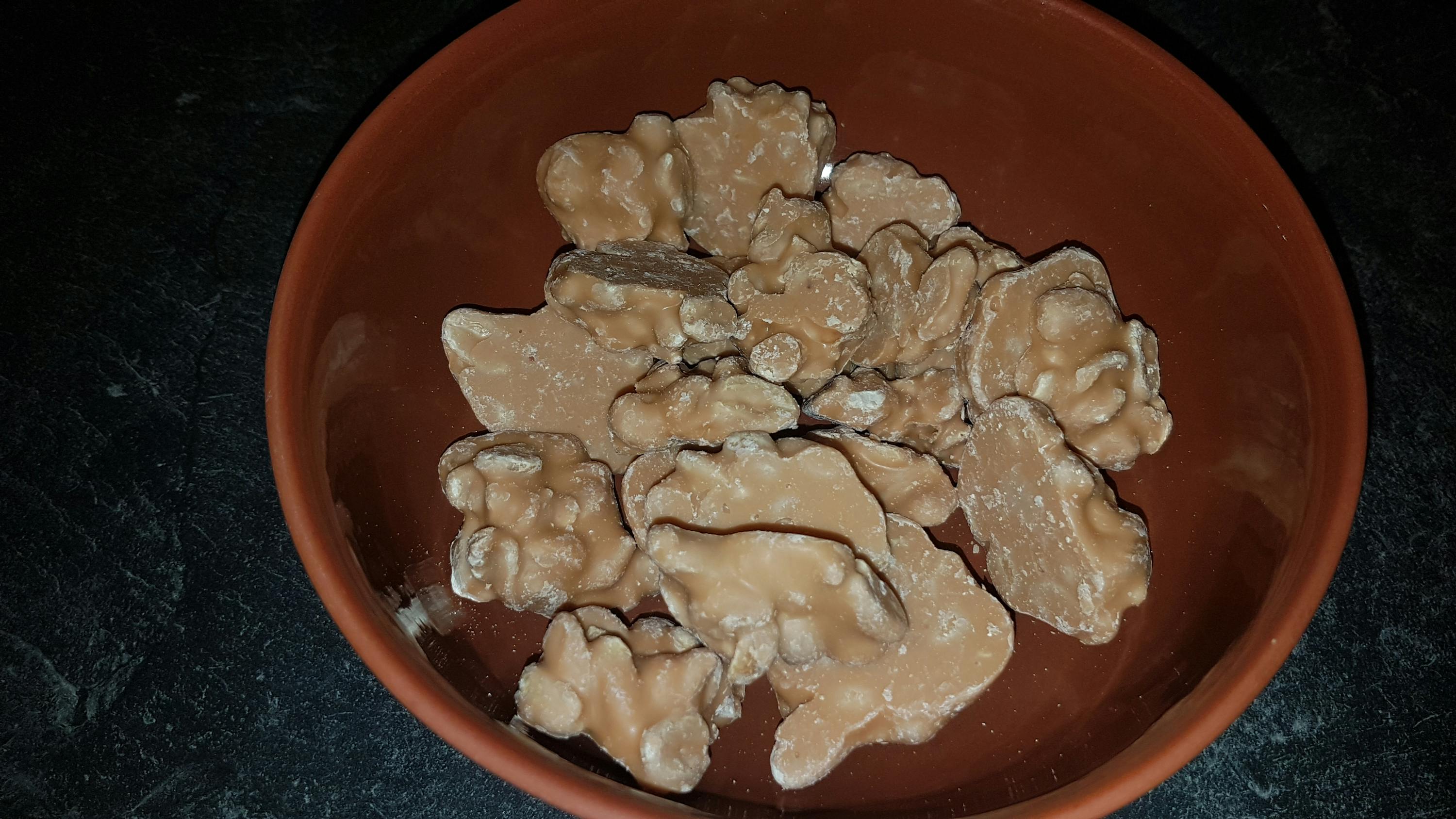 una ciotola piena di noci coperte di cioccolato bianco