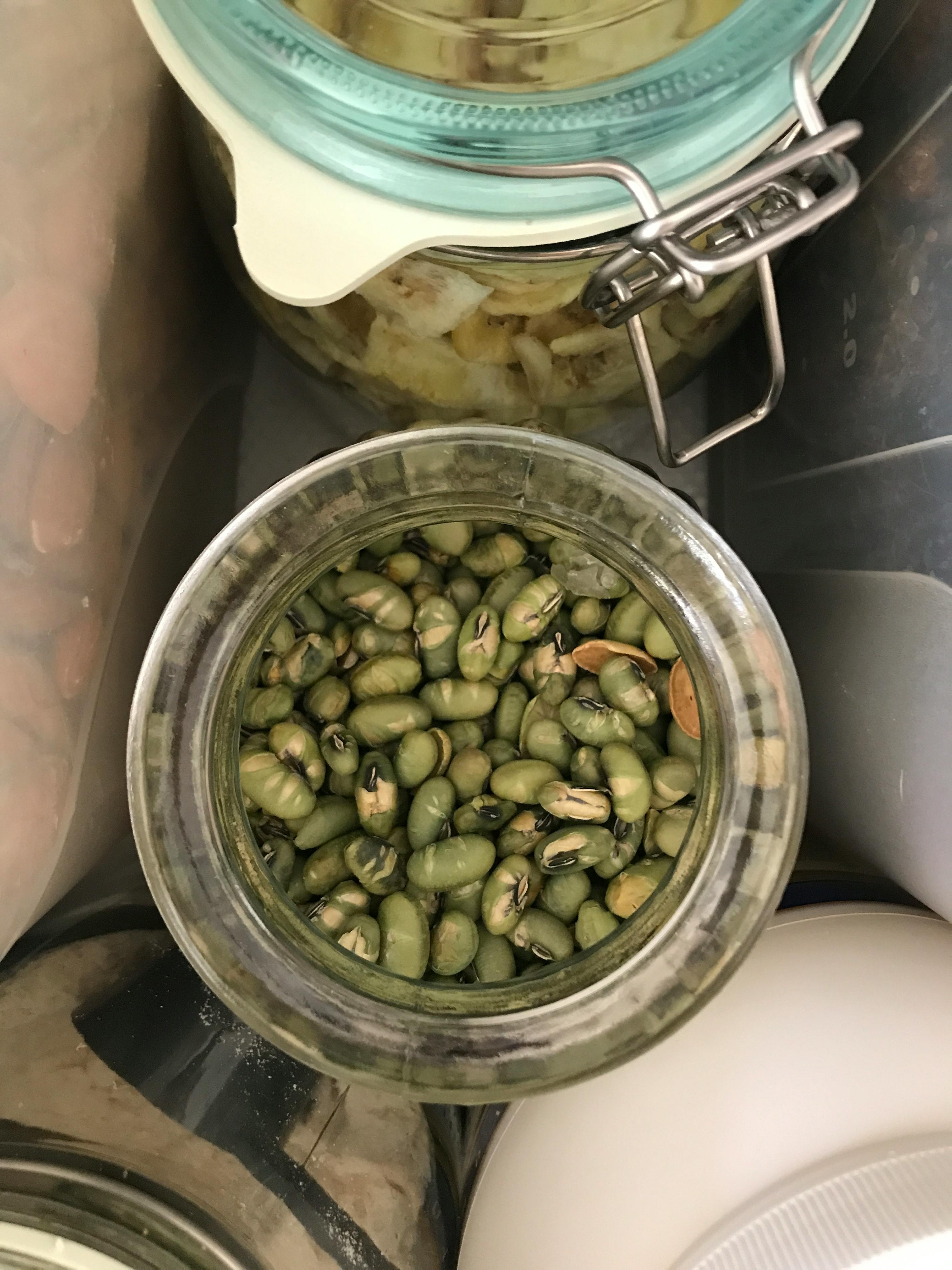 a jar of green beans sits next to a jar of cauliflower