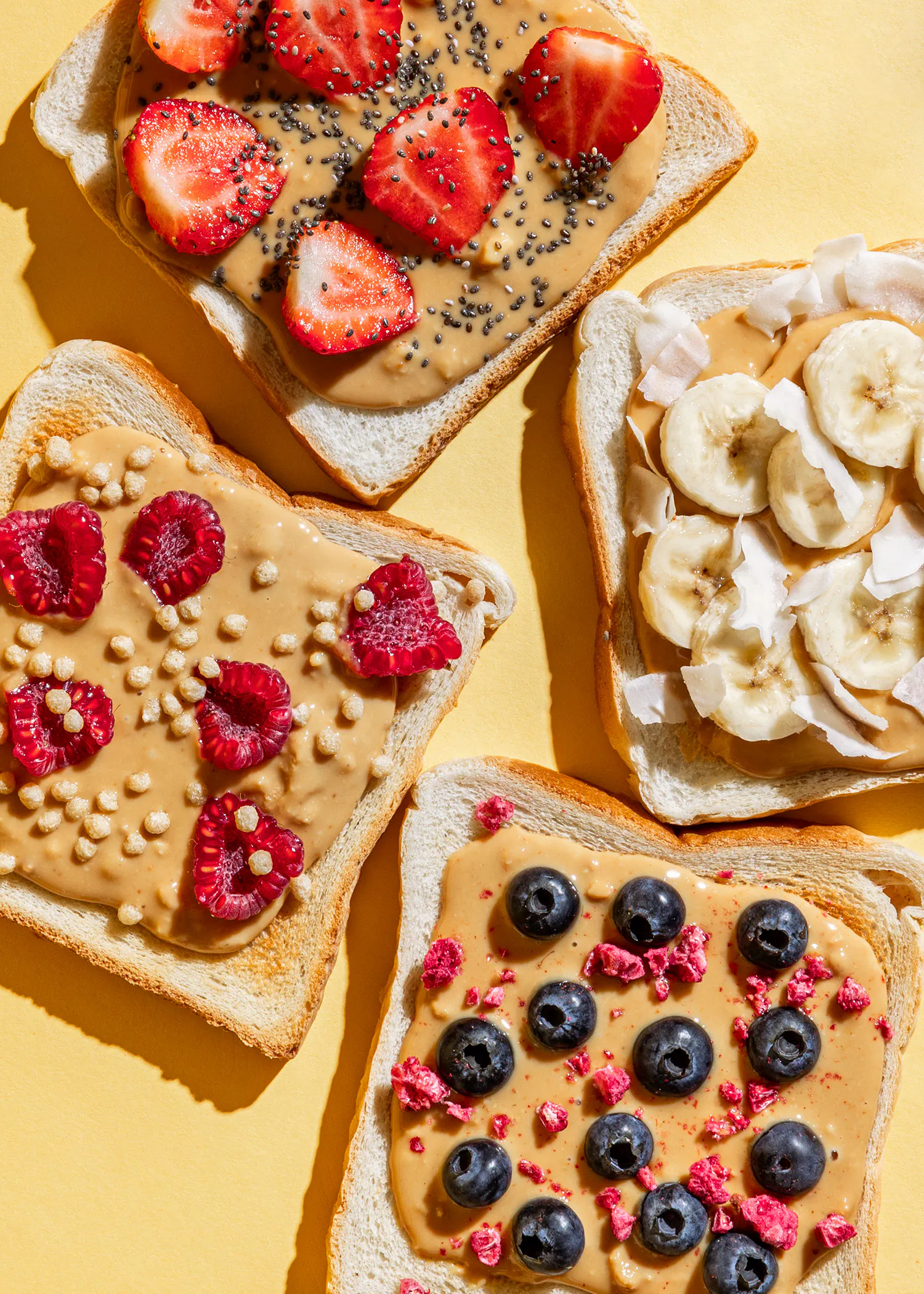trois tranches de pain avec du beurre d' arachide et des fruits