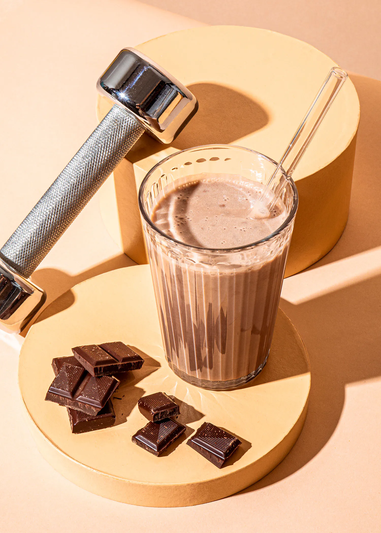 un smoothie au chocolat est assis sur une assiette à côté d' un haltère
