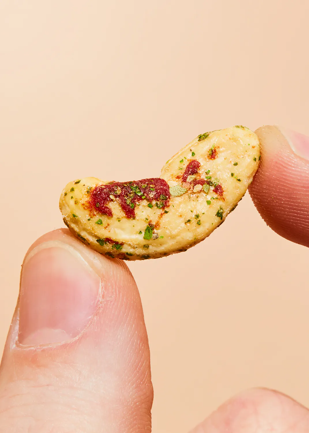 une personne tient un morceau de nourriture entre deux doigts