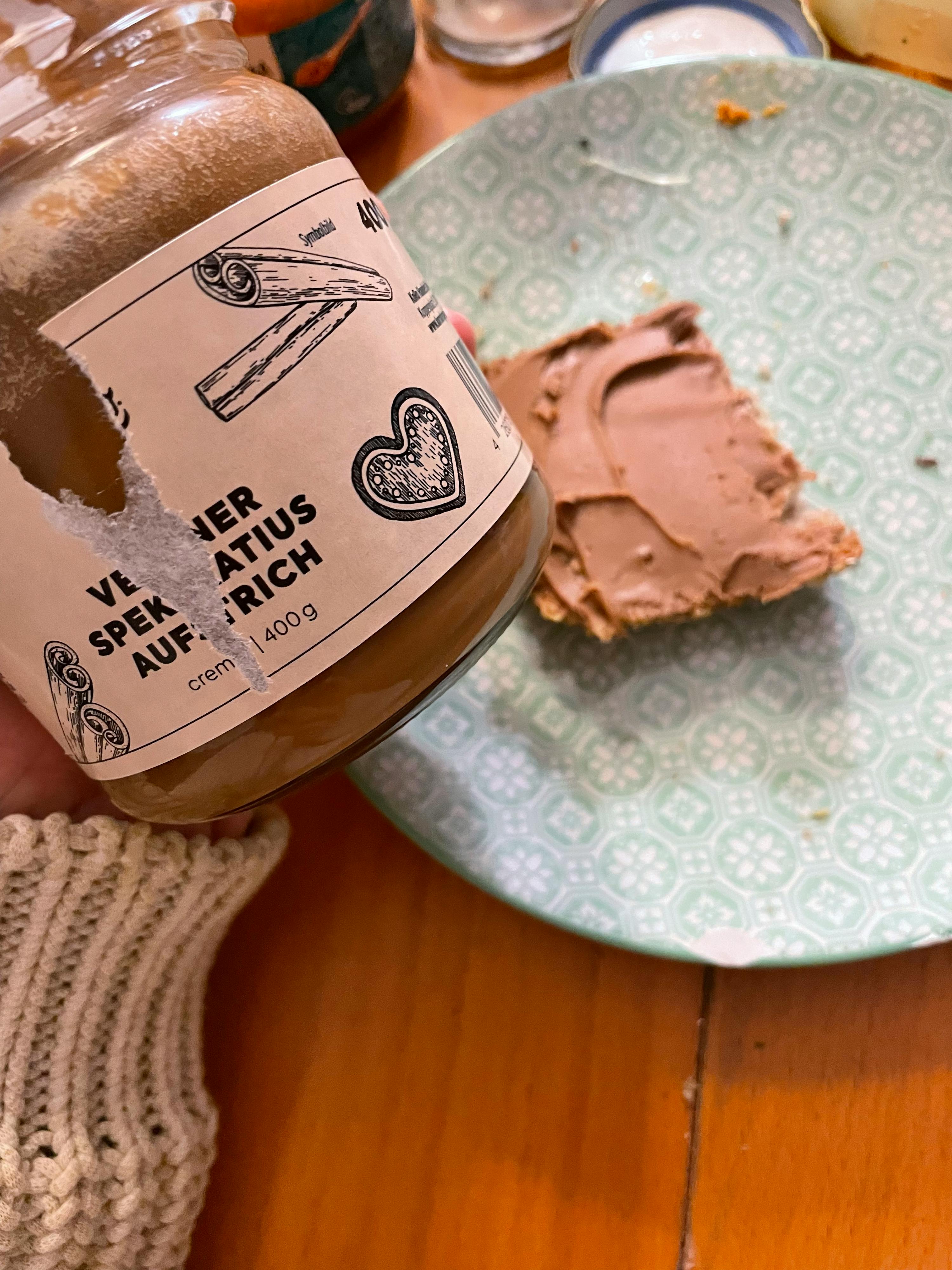 eine Person hält ein Glas Schokoladencreme mit einem gebrochenen Deckel