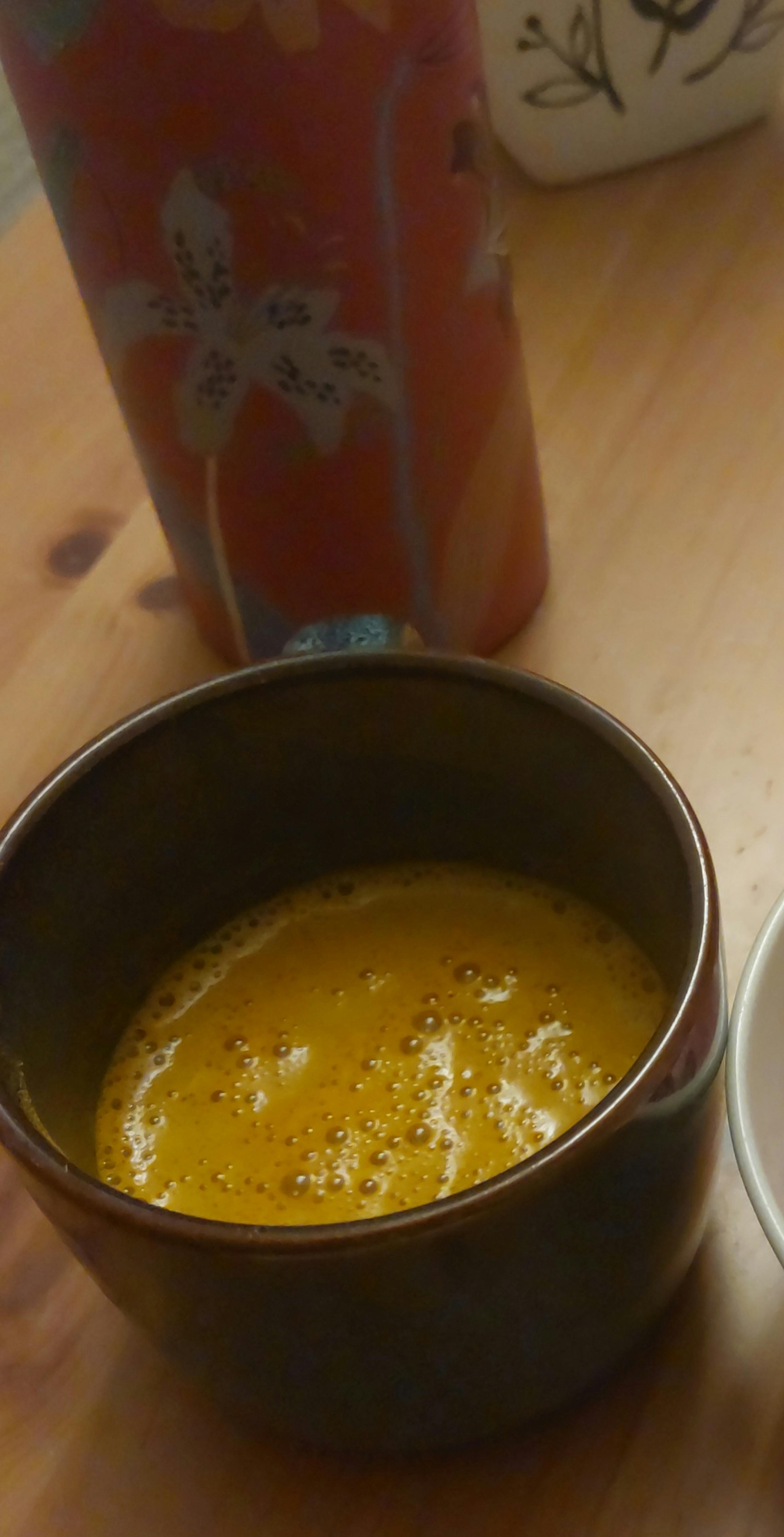 eine Nahaufnahme einer Schüssel Suppe auf einem Holztisch