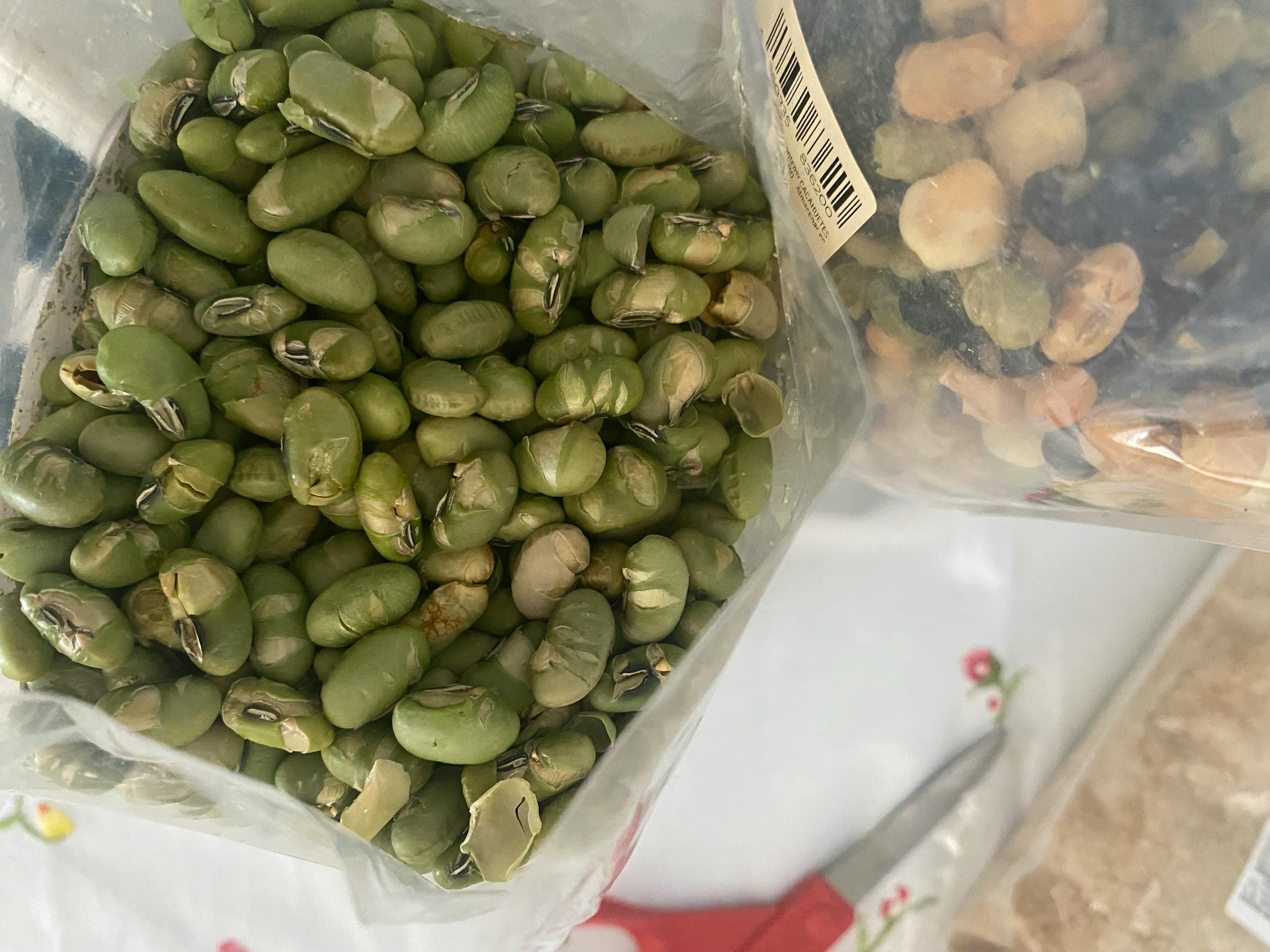 a bag of green beans sits next to a bag of black beans