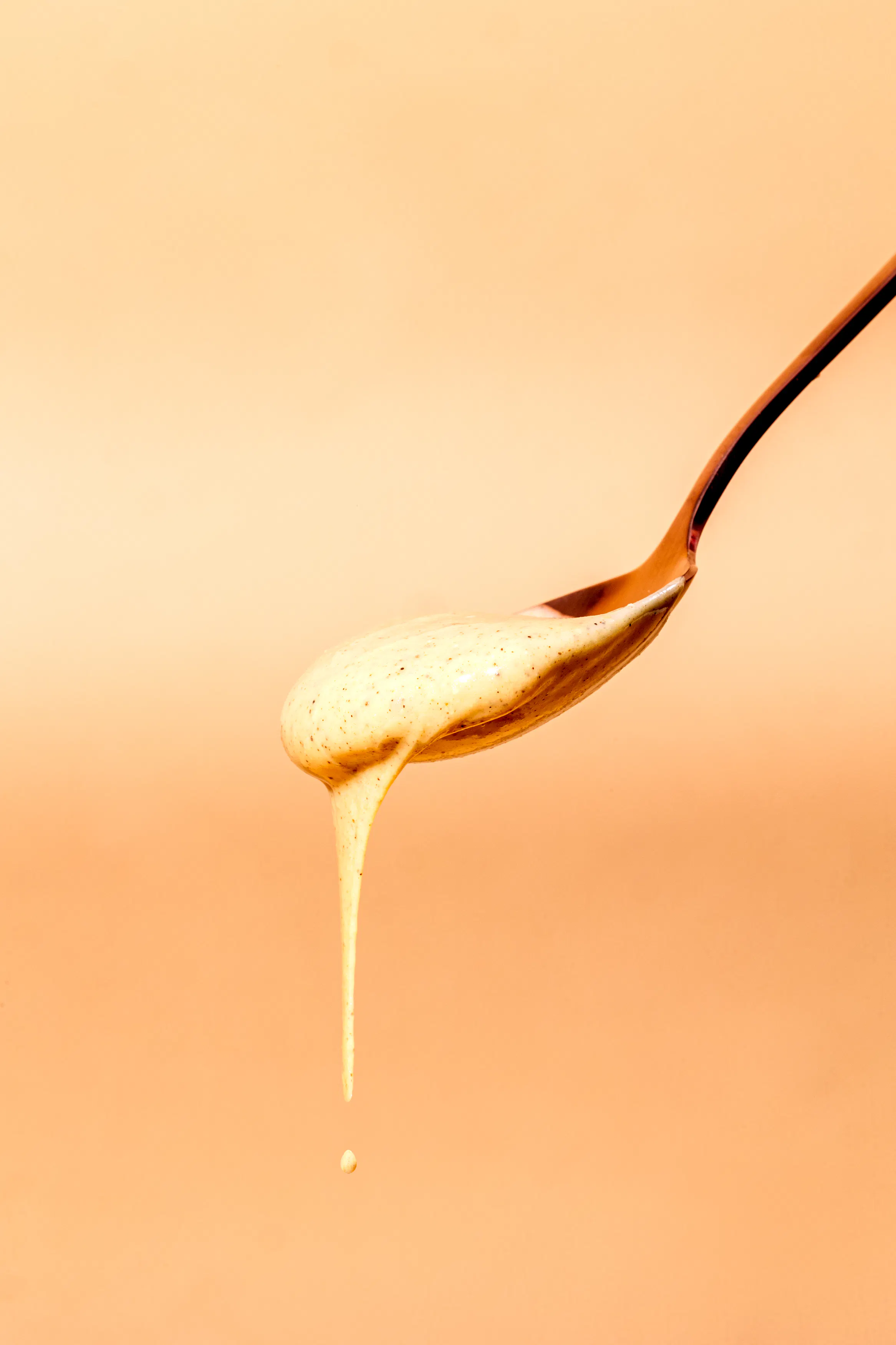 un cucchiaio con un liquido giallo che scorre da esso