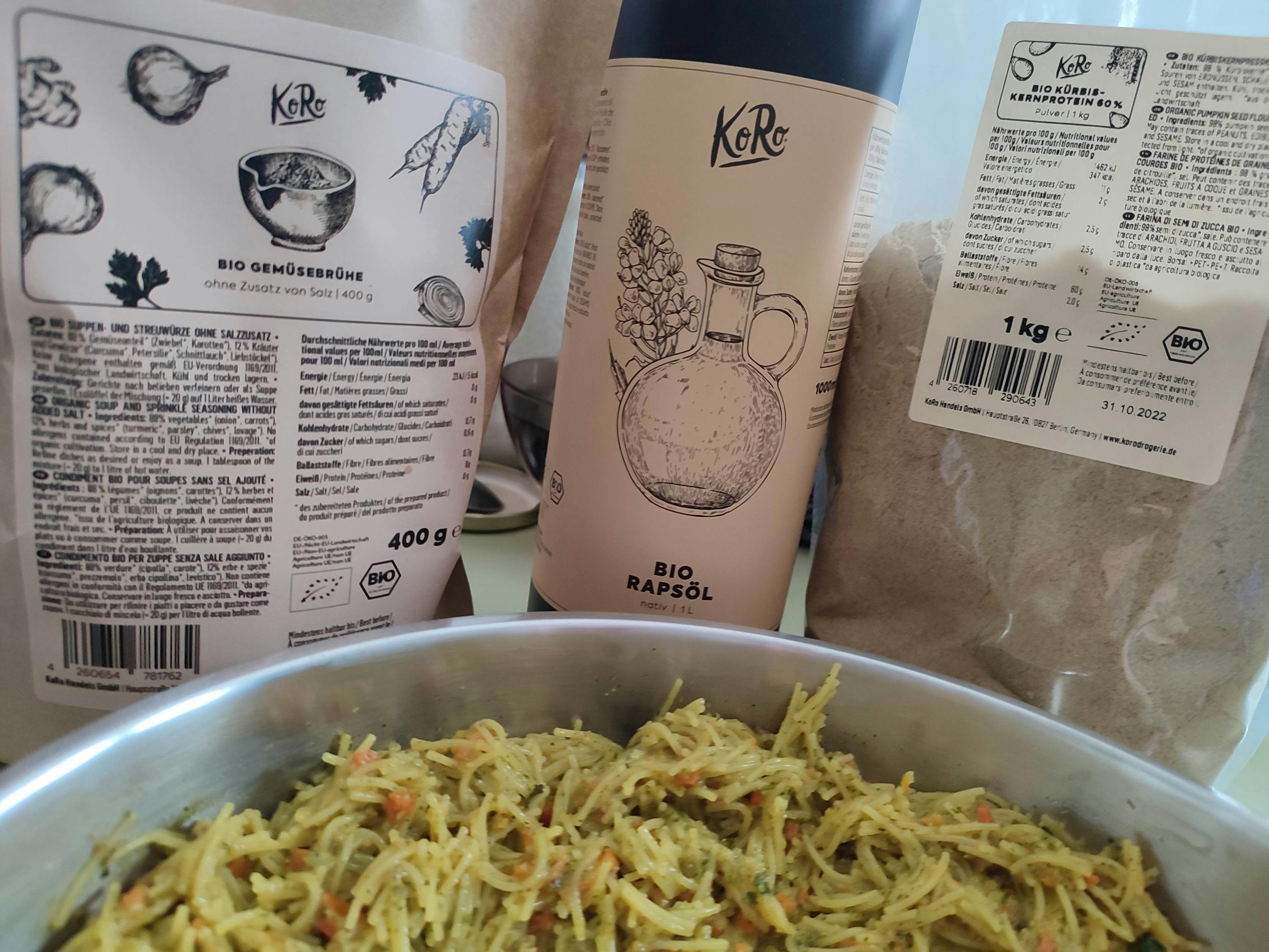 eine Flasche bio Rapsol steht neben einem Topf Nudeln