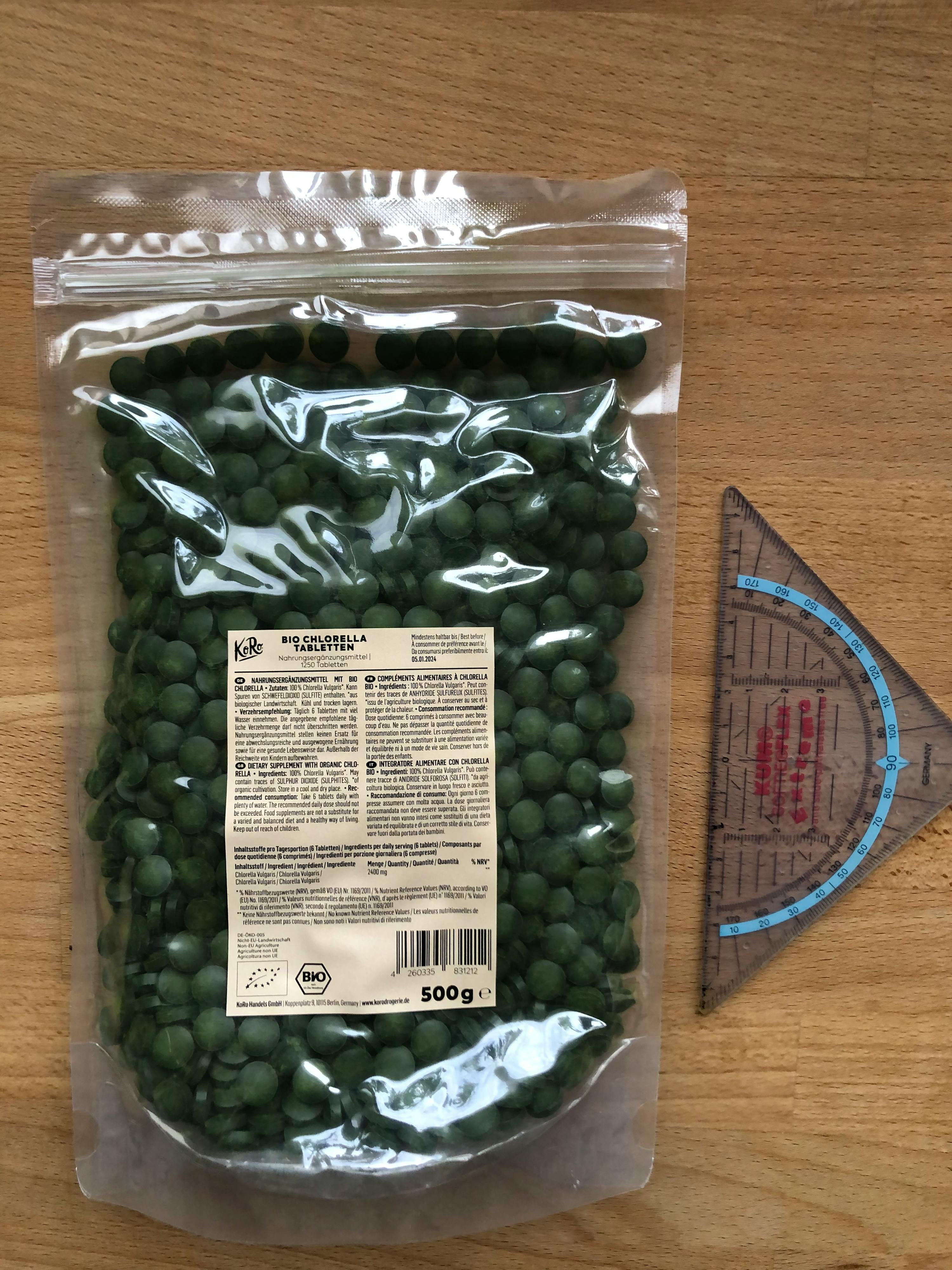 un sac de pois verts est assis sur une table en bois