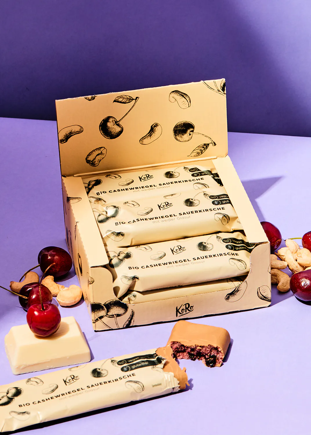 une boîte de barres de céréales avec des cerises et des noix dessus