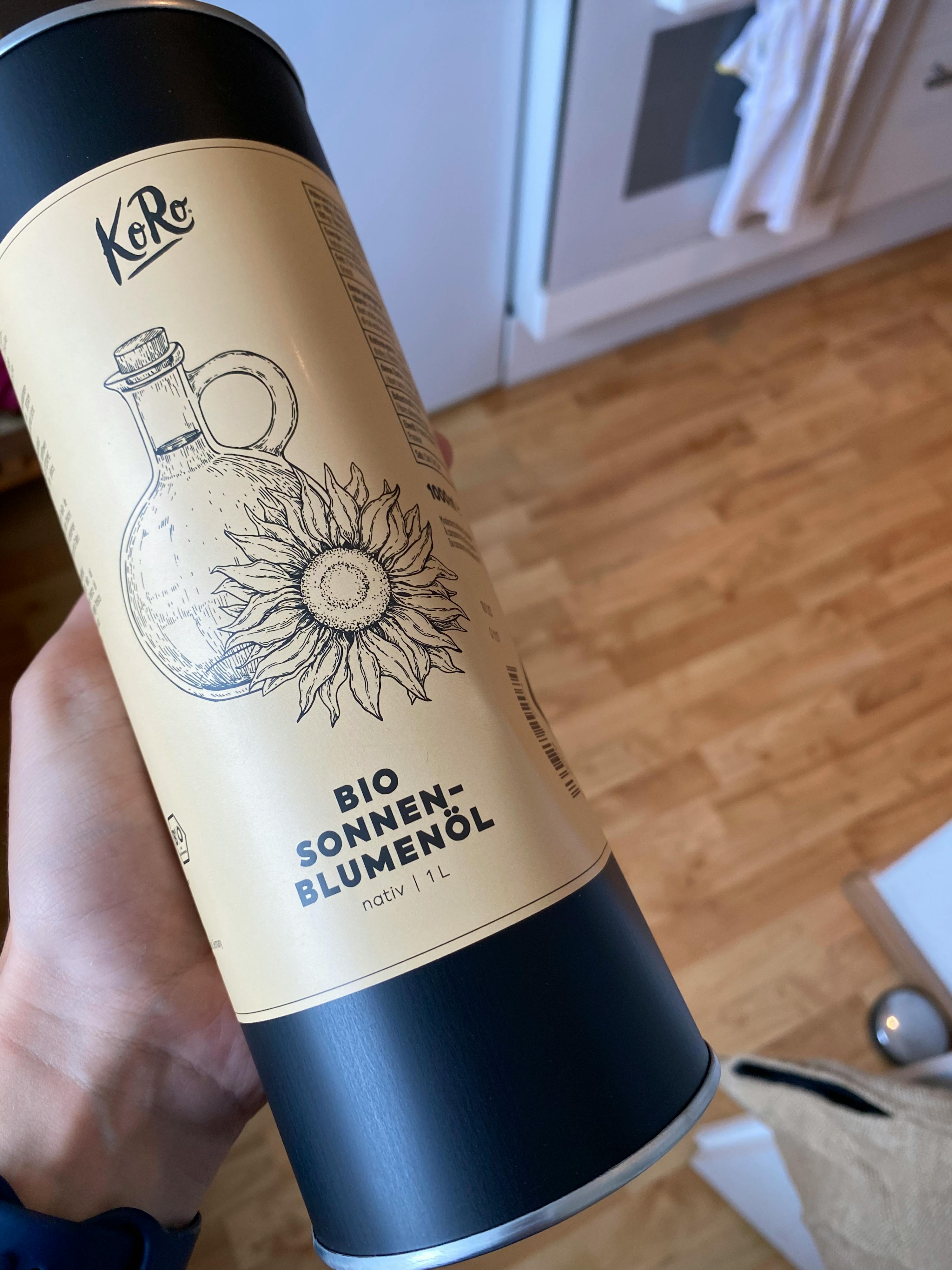 eine Person hält eine Dose Sonnenblumenöl in ihrer Hand