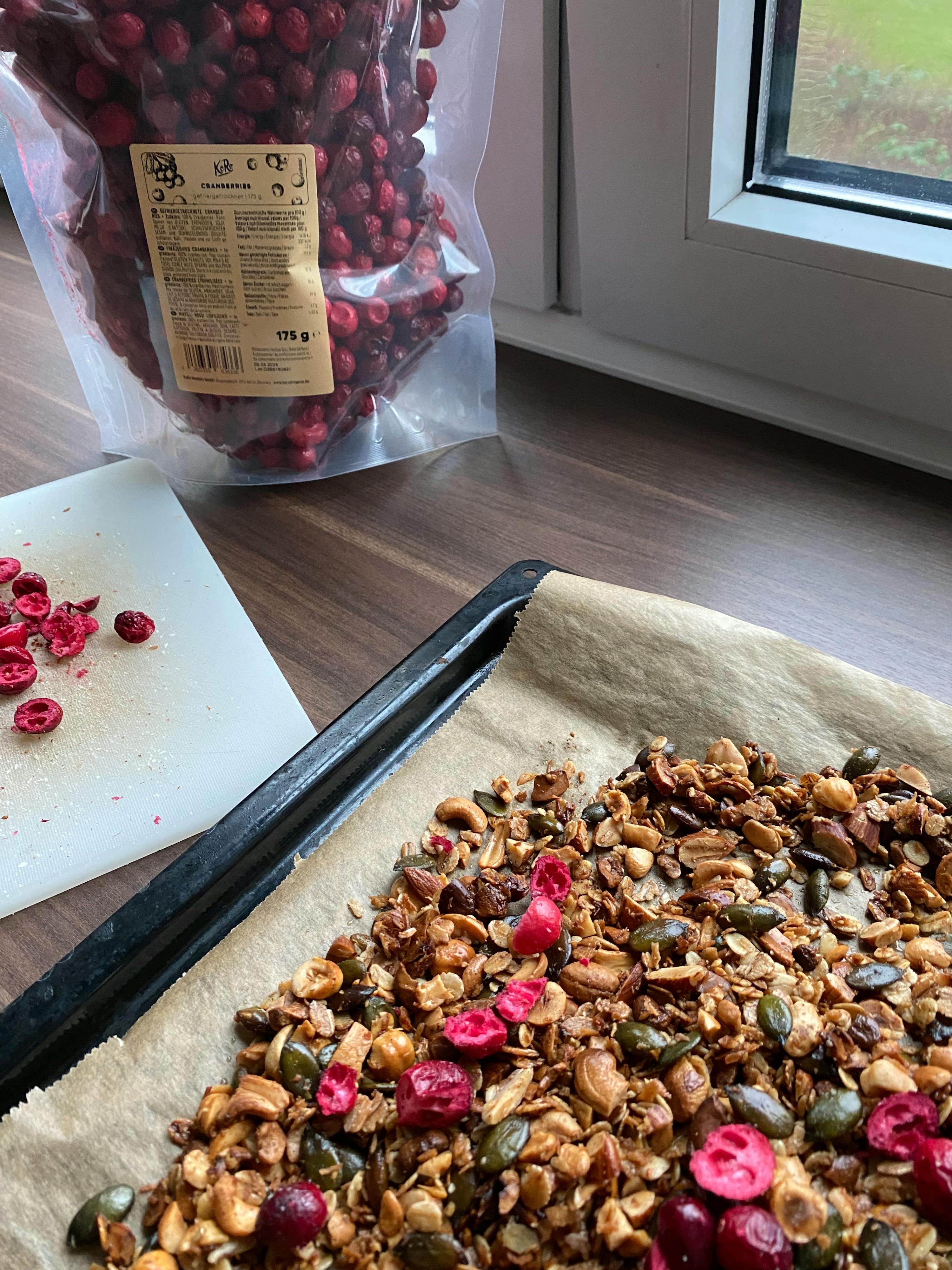 a bag of cranberries sits next to a tray of granola