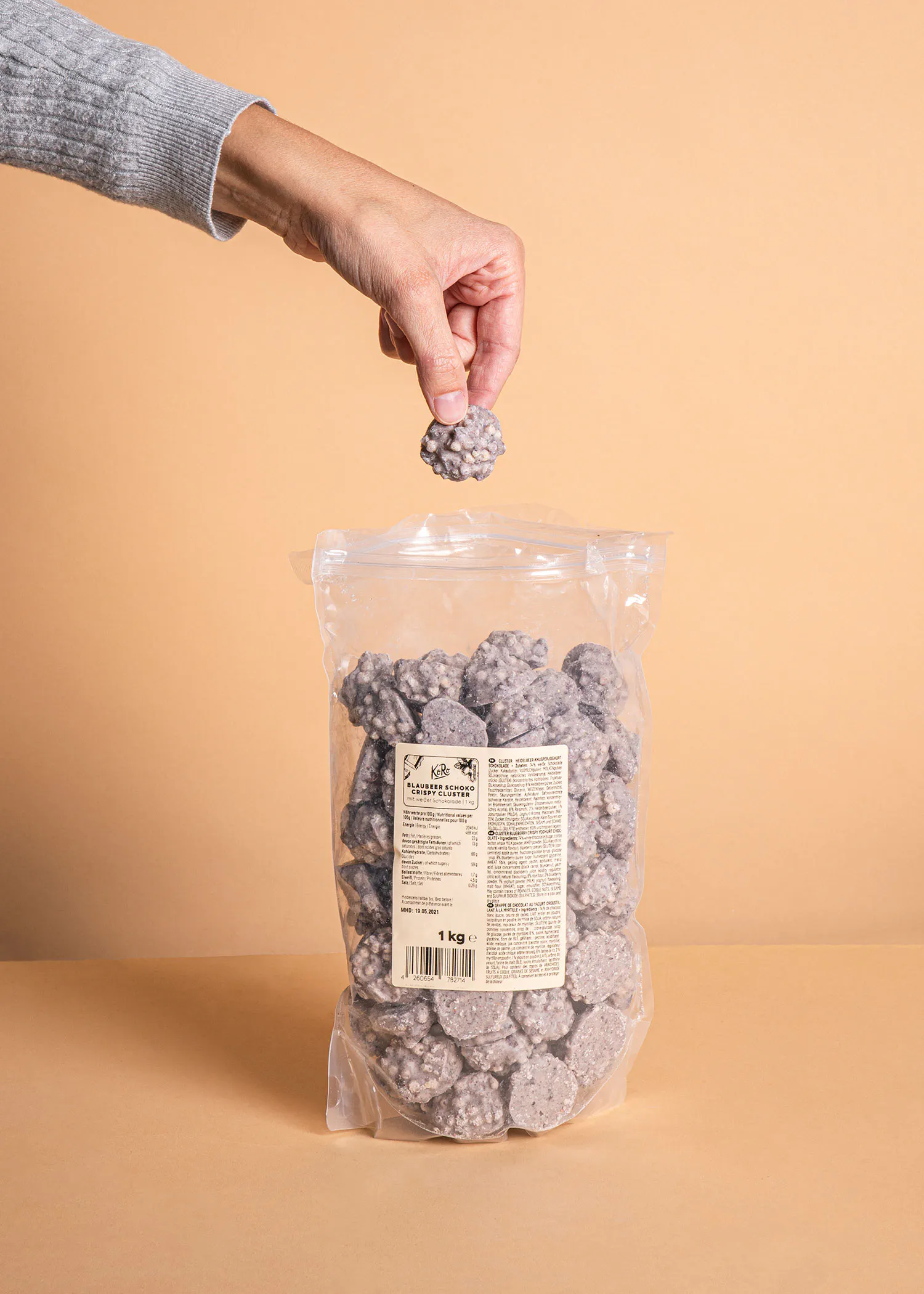 Eine Person hält einen Stück Schokolade aus einem Plastikbeutel