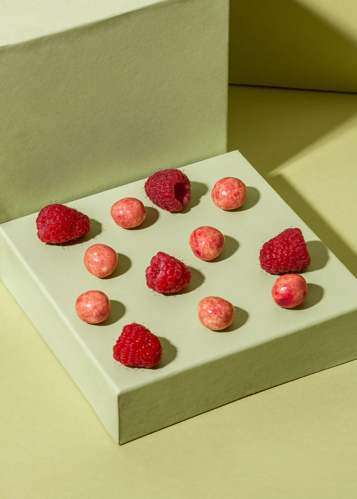 a tray of raspberries and candy on a table