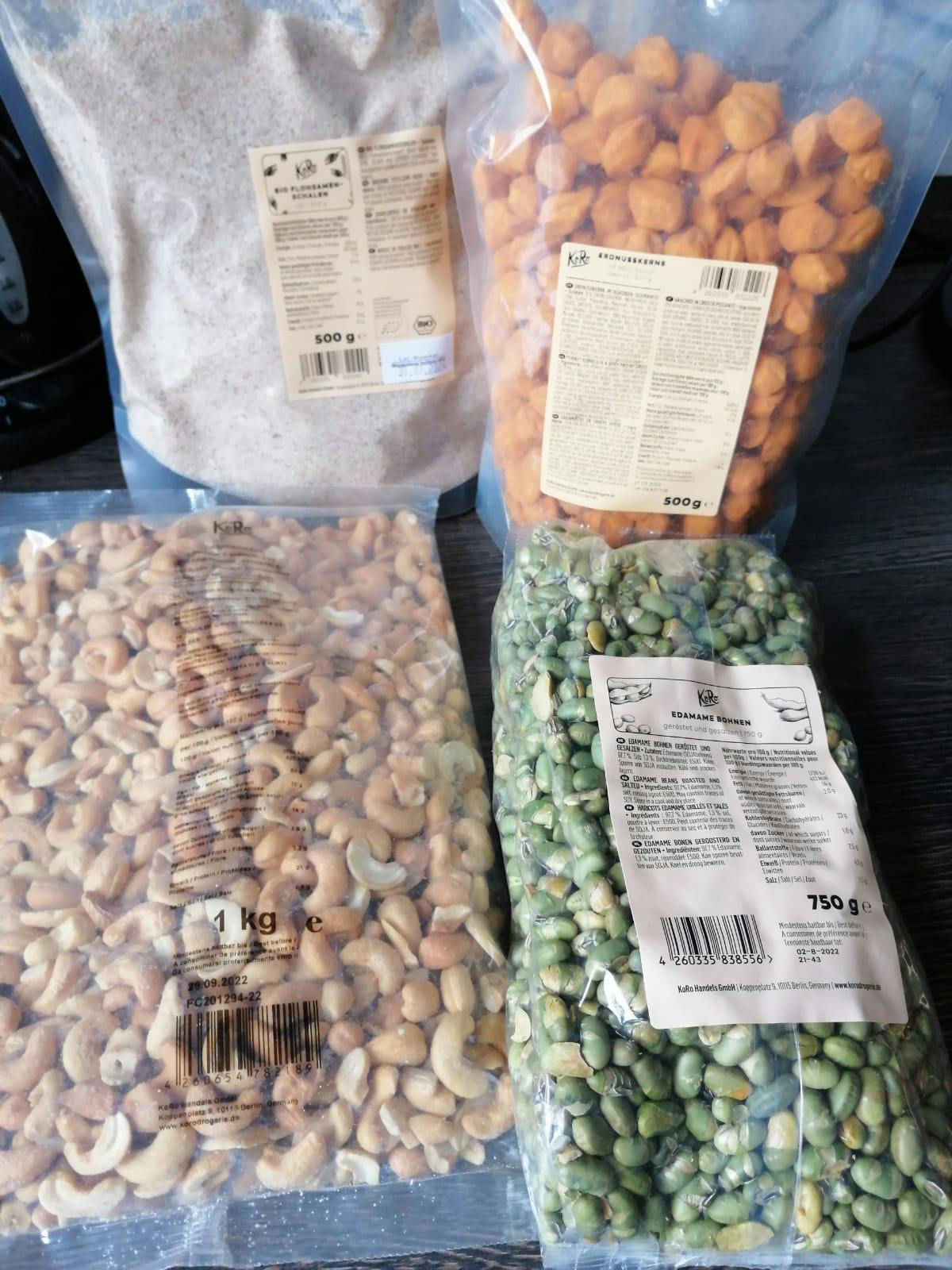 eine Tüte Cashewnüsse steht neben einer Tüte grünen Bohnen