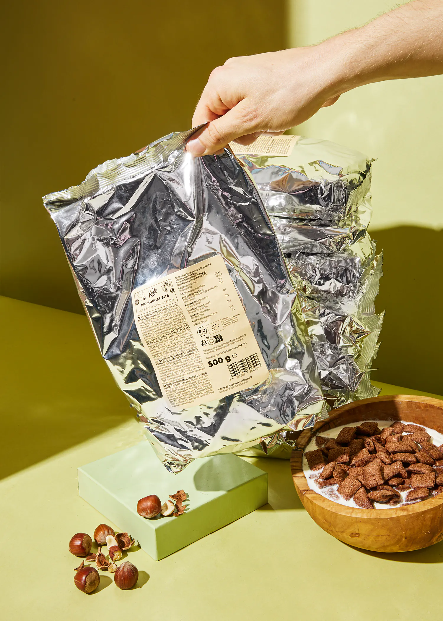 una persona tiene in mano un sacchetto di cioccolato e un piatto di cereali