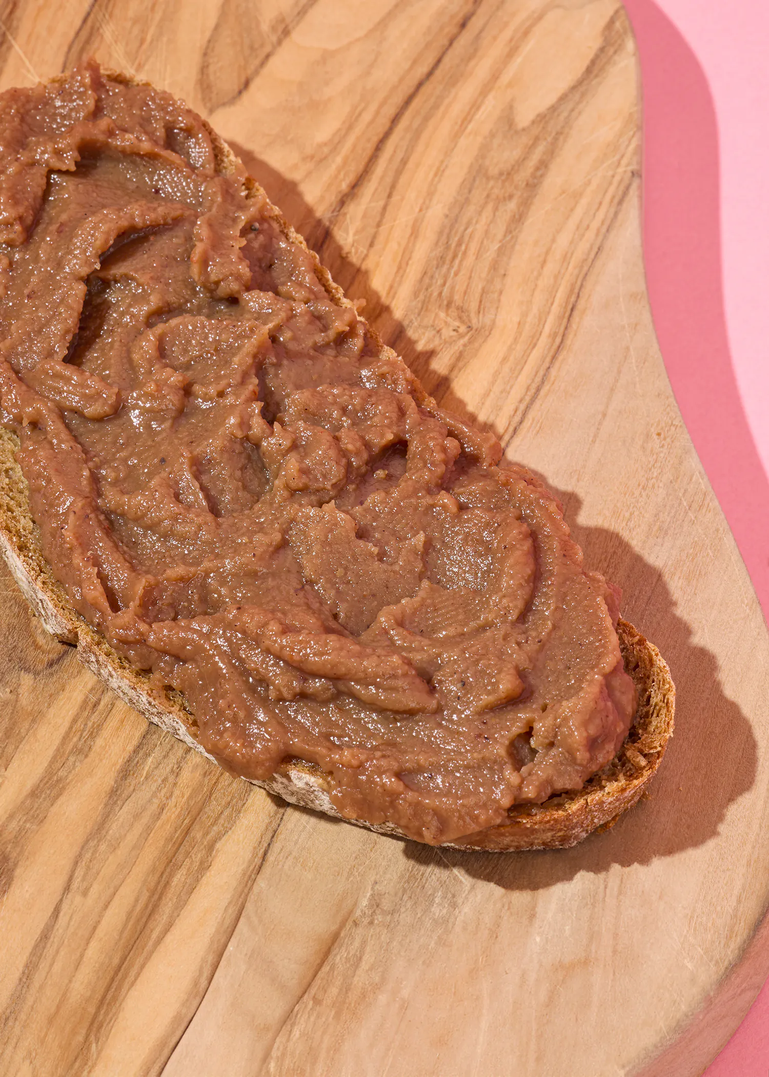 ein Stück Brot mit Schokoladenmarmelade auf einem Schneidebrett
