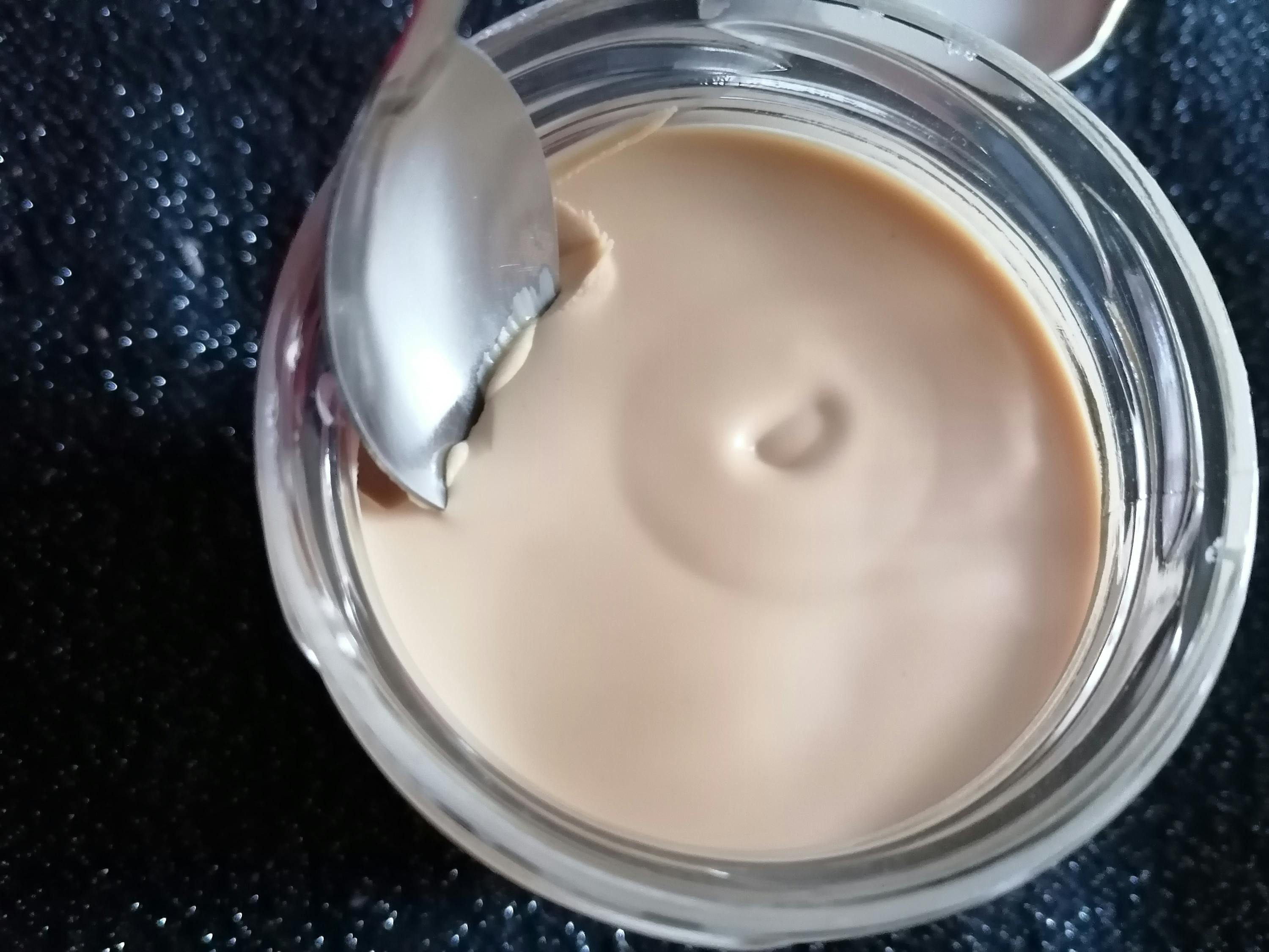 a spoon is sticking out of a jar of cream