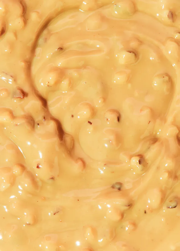 un gros plan d' une sauce au chocolat avec des noix