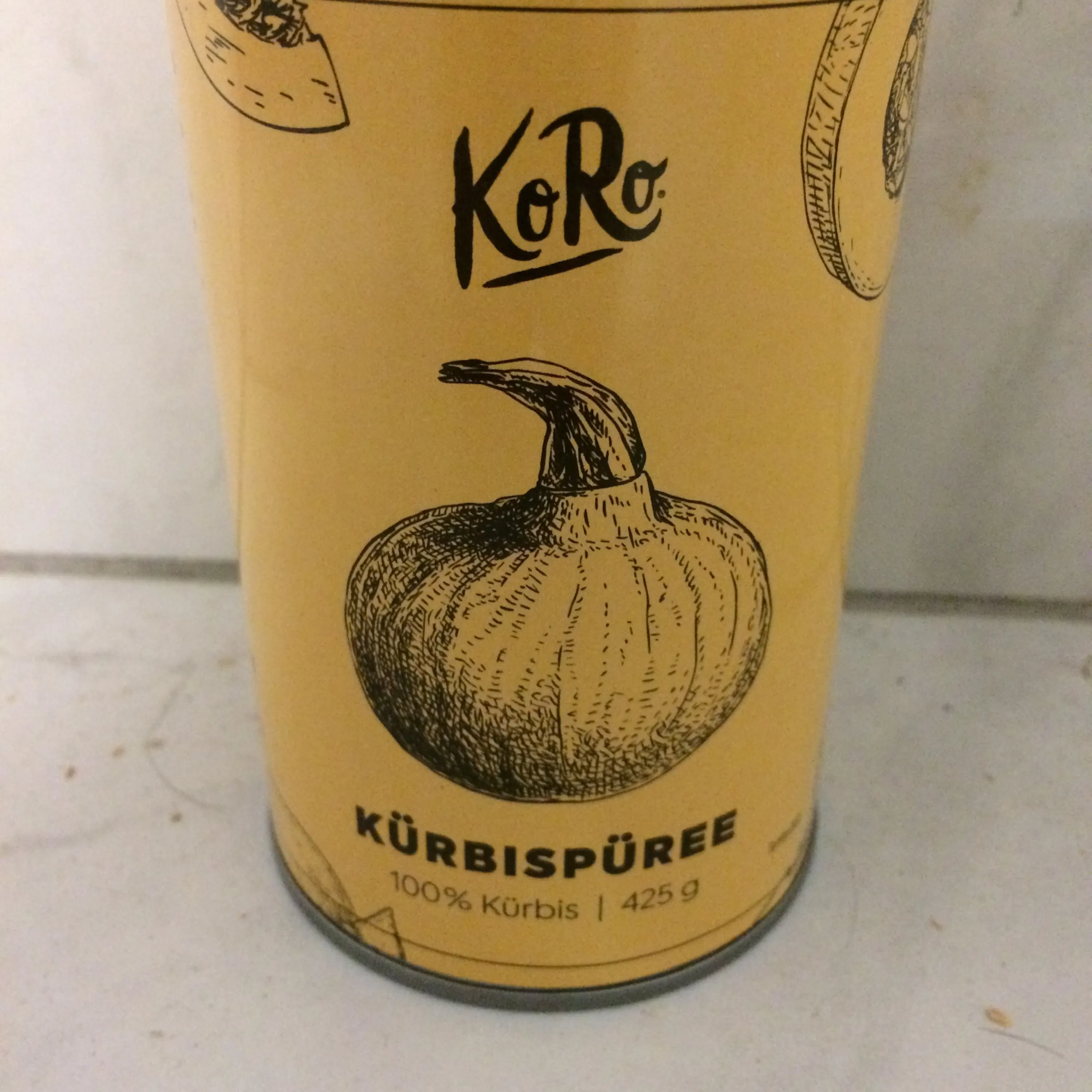 Eine Dose Kürbispüree mit einem Kürbis darauf