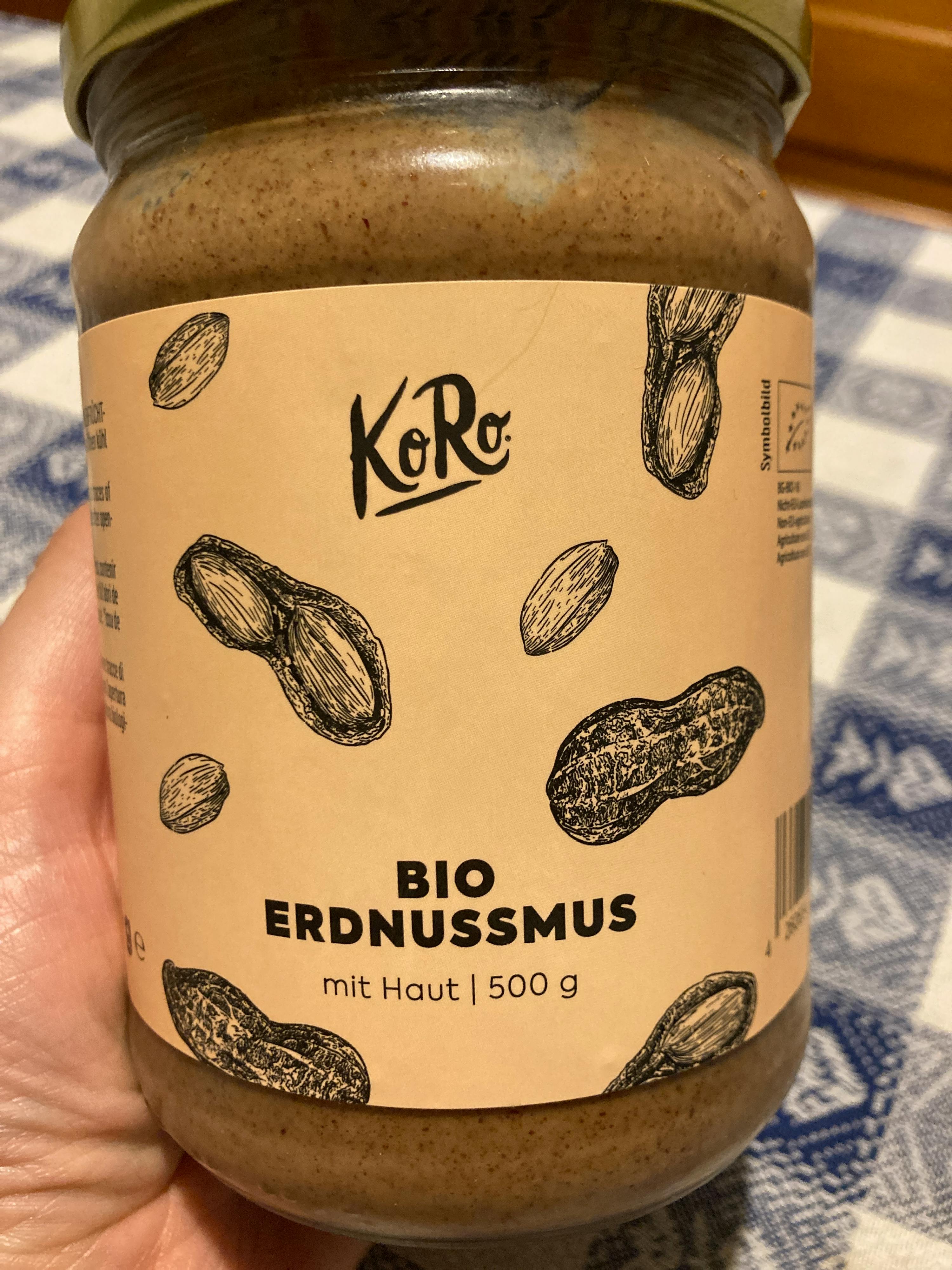 une personne tient un pot de beurre d' arachide bio