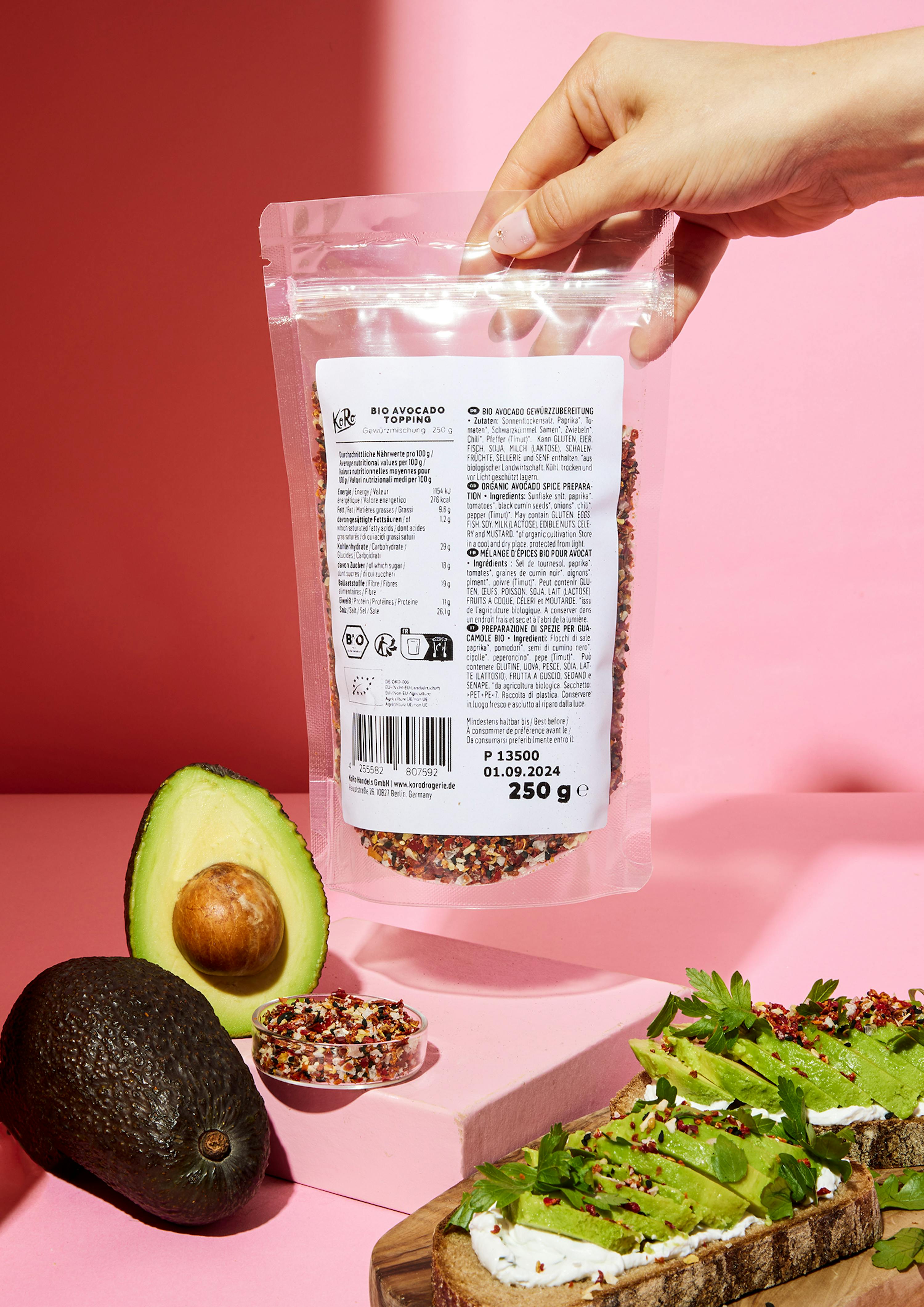 une personne tient un sac de garniture d' avocat sur une table rose