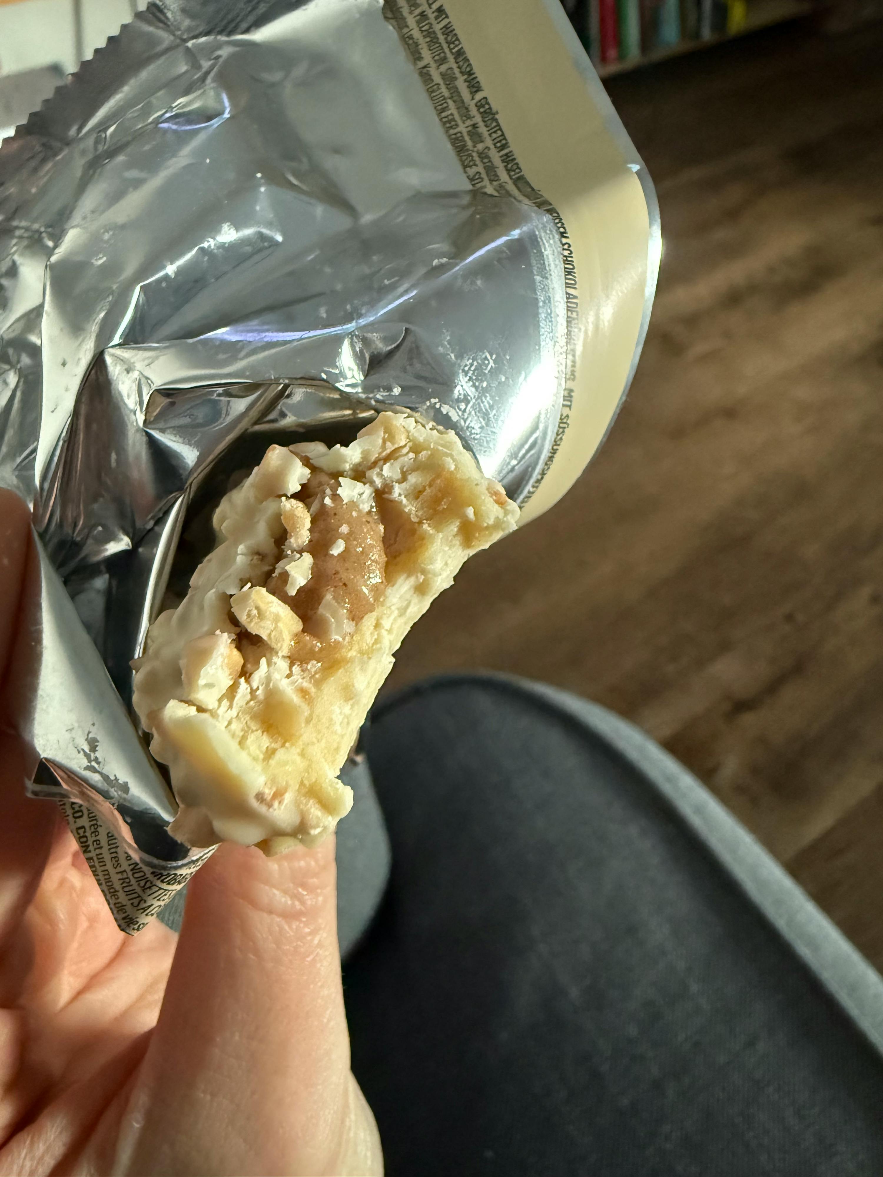 Eine Person hält einen Schokoladenriegel mit einem Stück herausgenommen