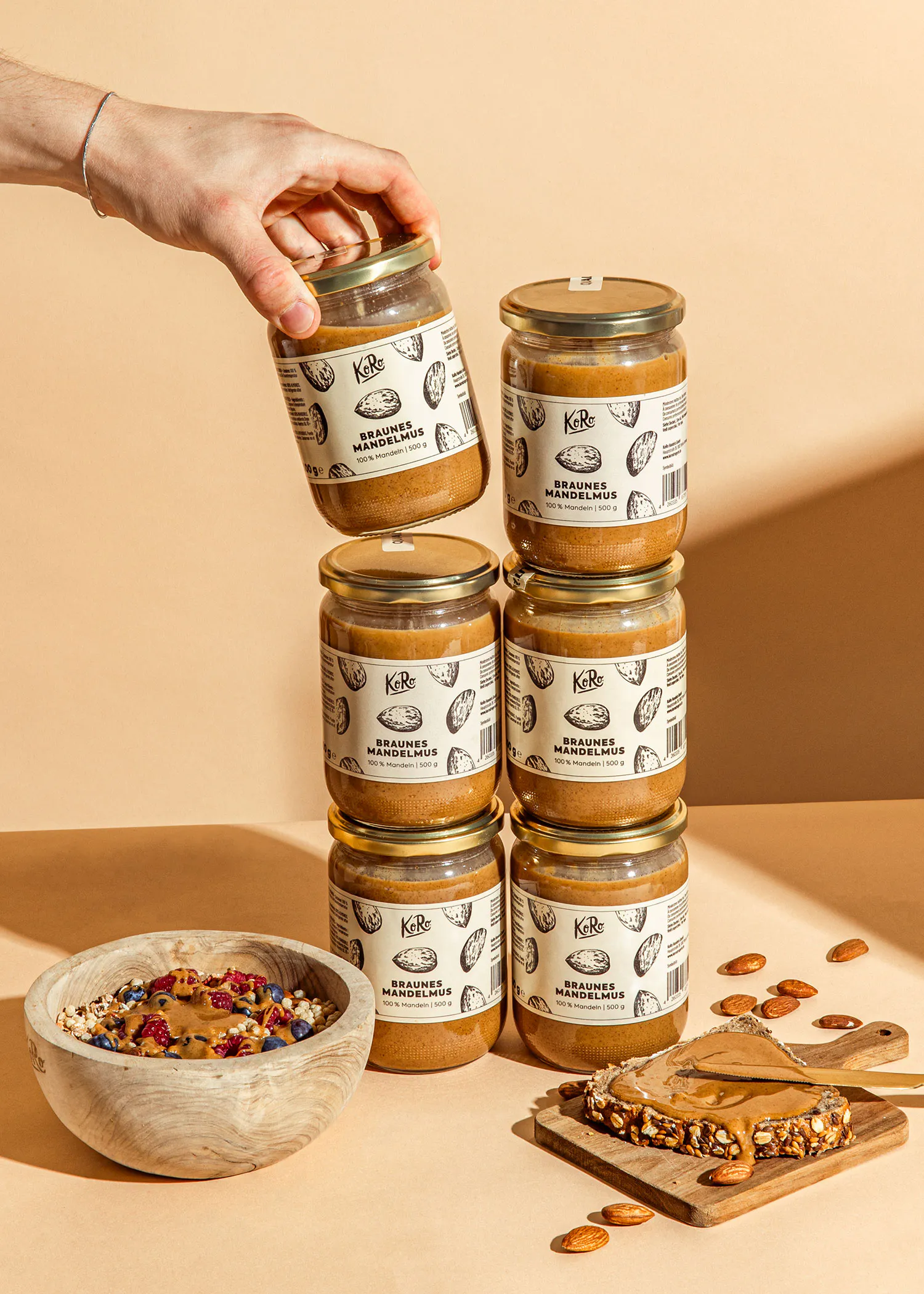 a person is reaching for a jar of braunes mandelmus