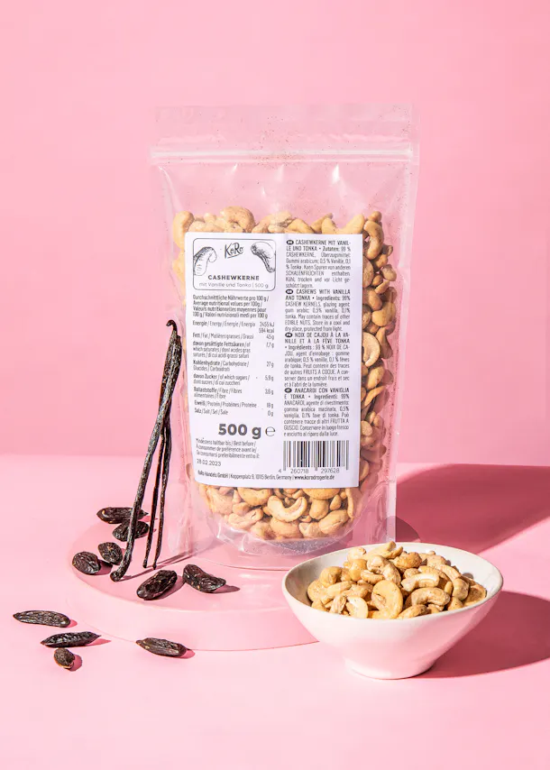 a bag of cashews sits next to a bowl of cashews