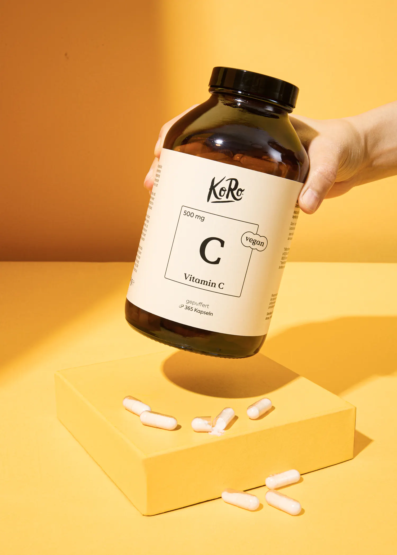 a person is holding a large bottle of vitamin c