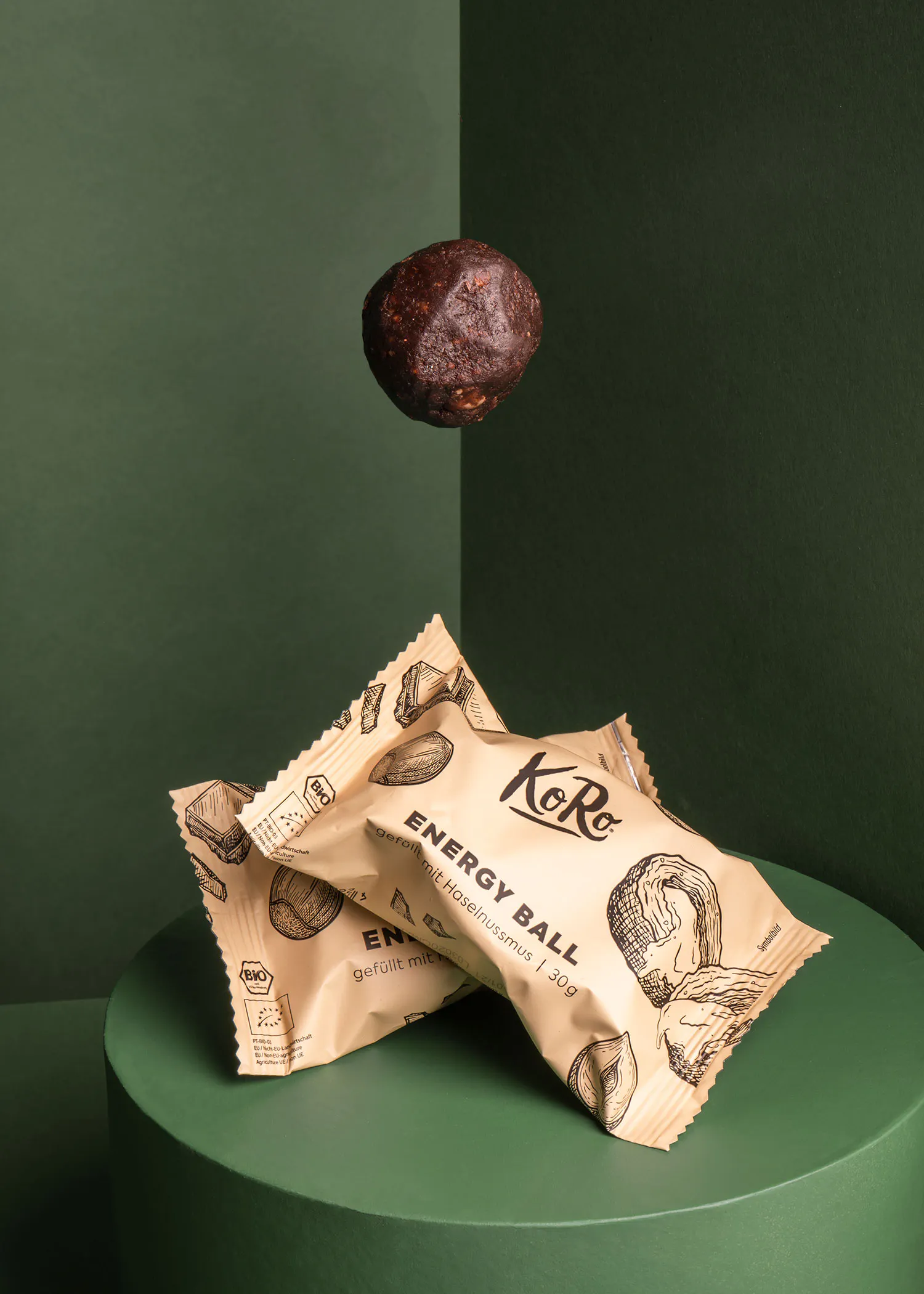 ein brauner energy ball liegt auf einem grünen podium