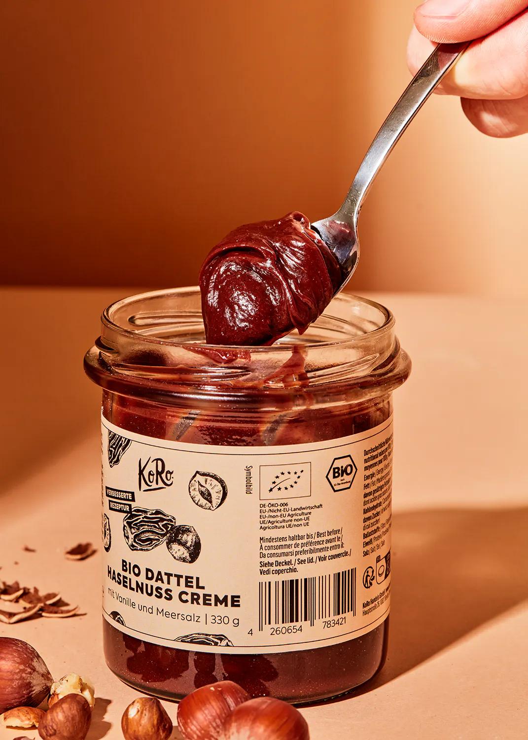 une personne tient une cuillère remplie de creme de dattel bio